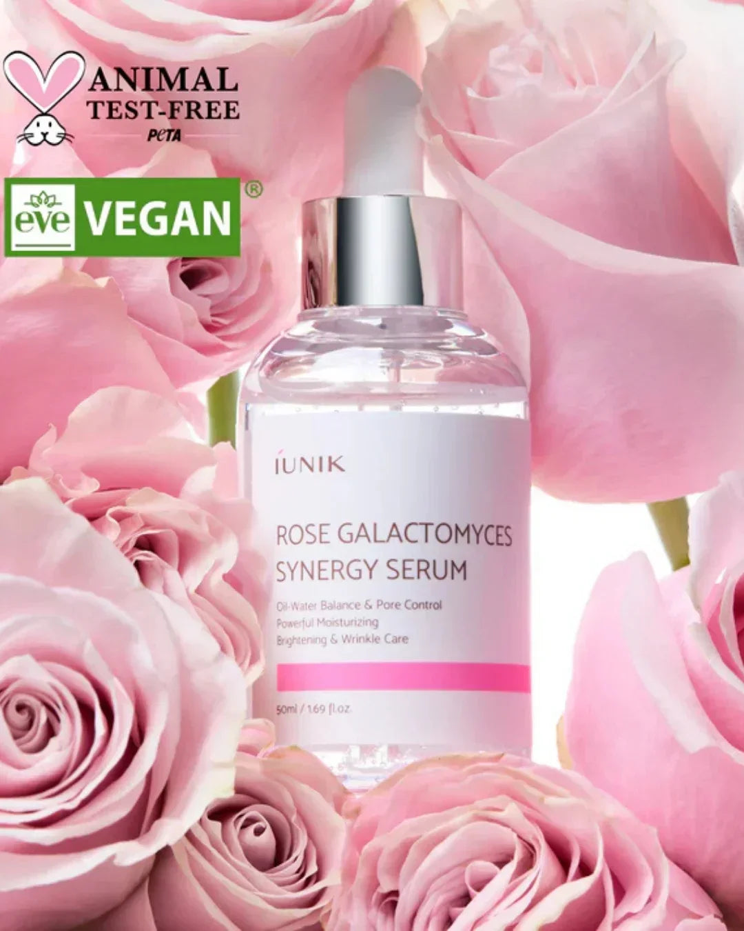 IUNIK Rose Galactomyces Synergy Serum bottle surrounded by pink roses, highlighting vegan and animal test-free logos
