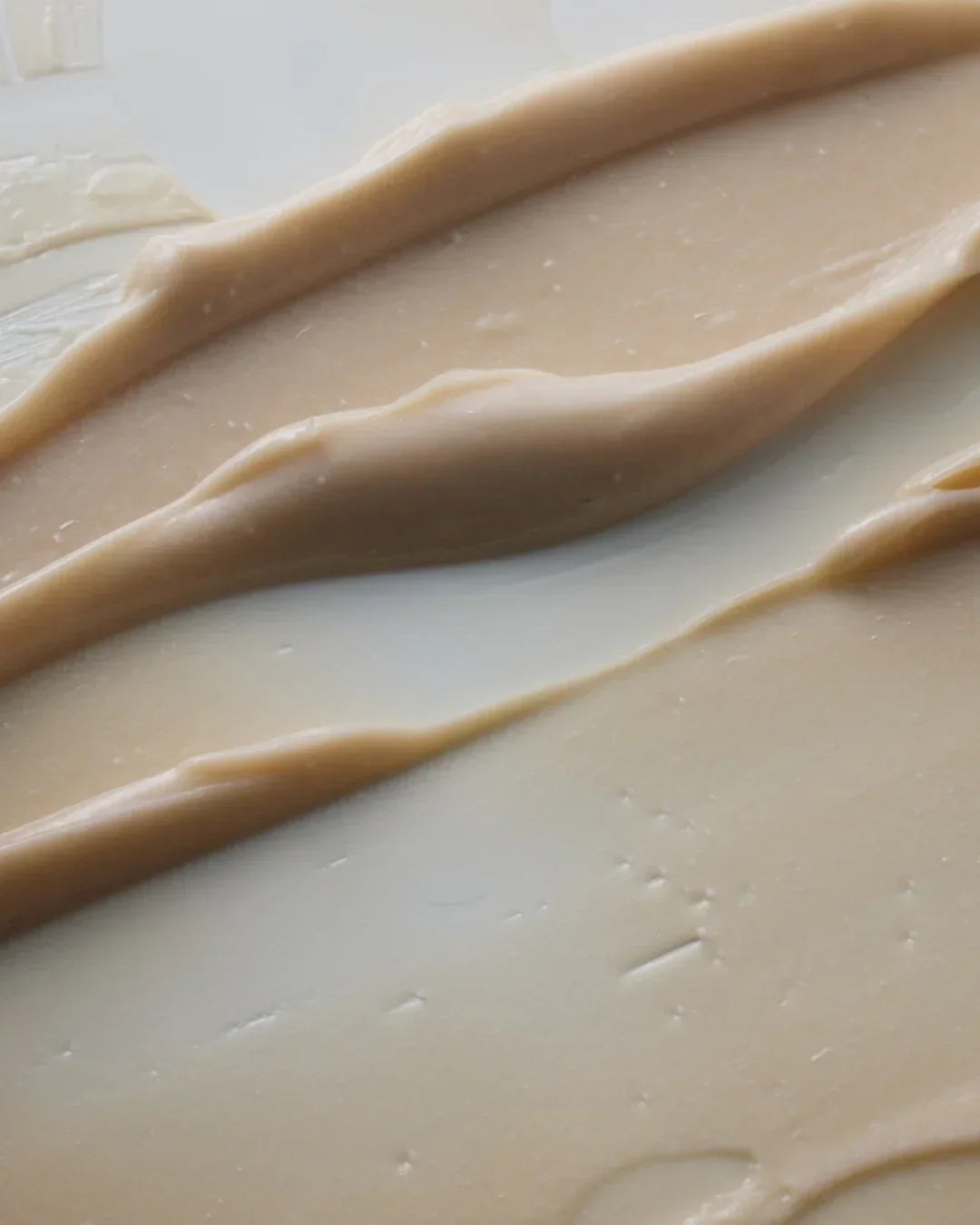 Close-up of beige sea salt scalp therapy cream texture spread on a smooth surface