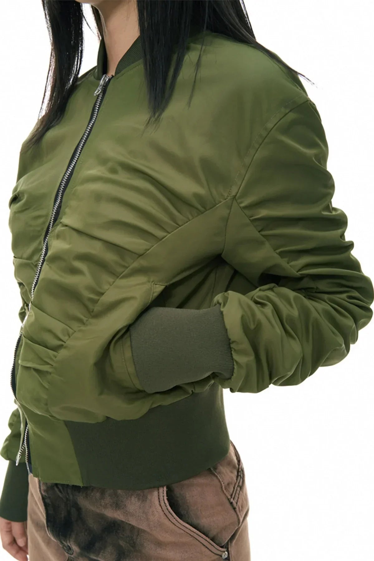 Close-up of woman wearing khaki green shirred bomber jacket with zip and cuffed sleeves