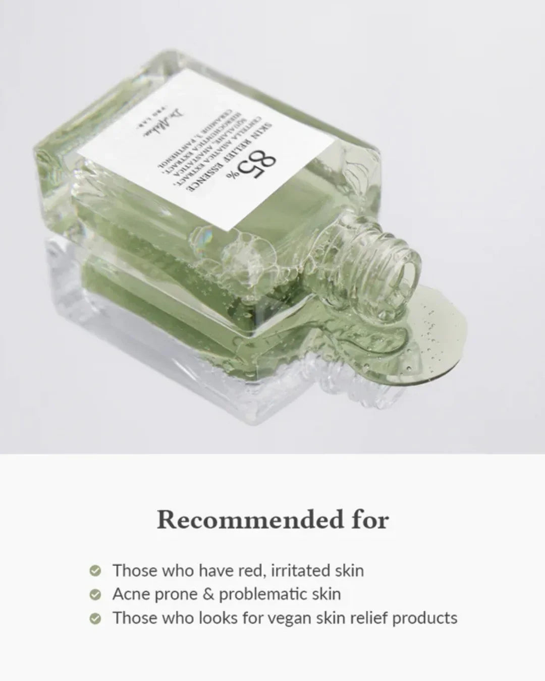 Open glass bottle of 85% skin relief essence spilling clear gel with bubbles on white background