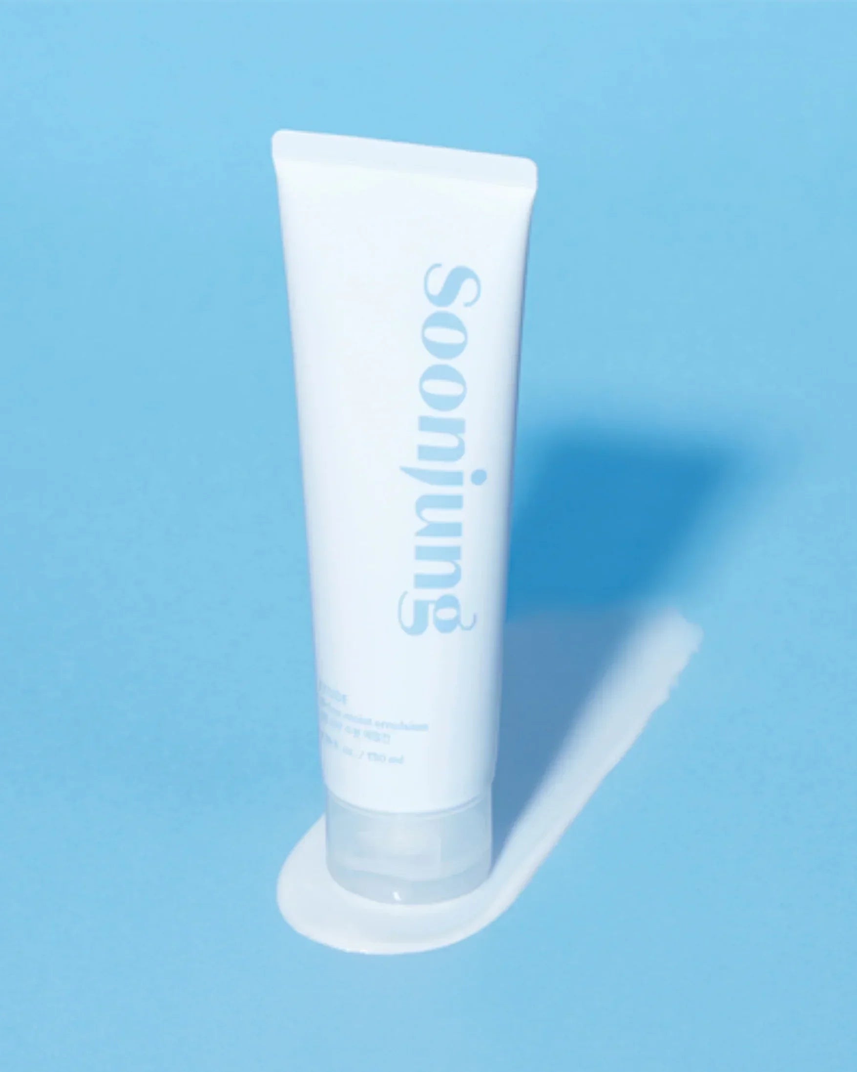 Soon Jung 10-Free Moist Emulsion tube on blue background with emulsion texture