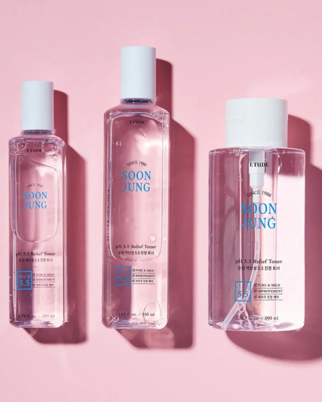 Three clear Soon Jung pH 5.5 Relief Toner bottles by Etude on pink background