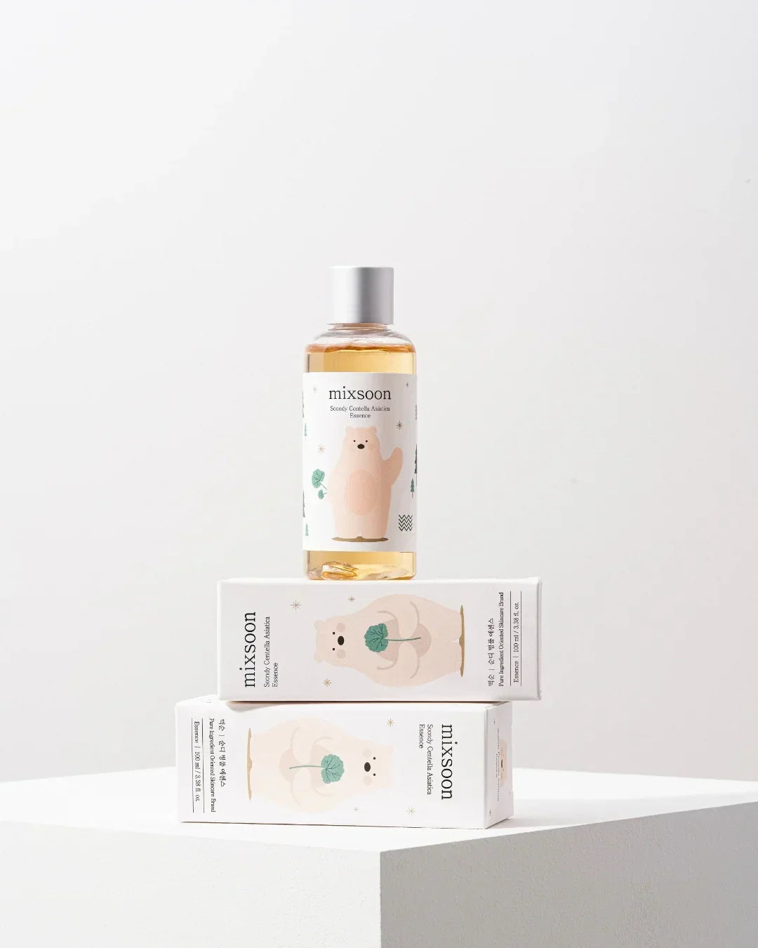 Mixsoon Soondy Centella Asiatica Essence skincare bottle and two product boxes with bear illustration on white pedestal