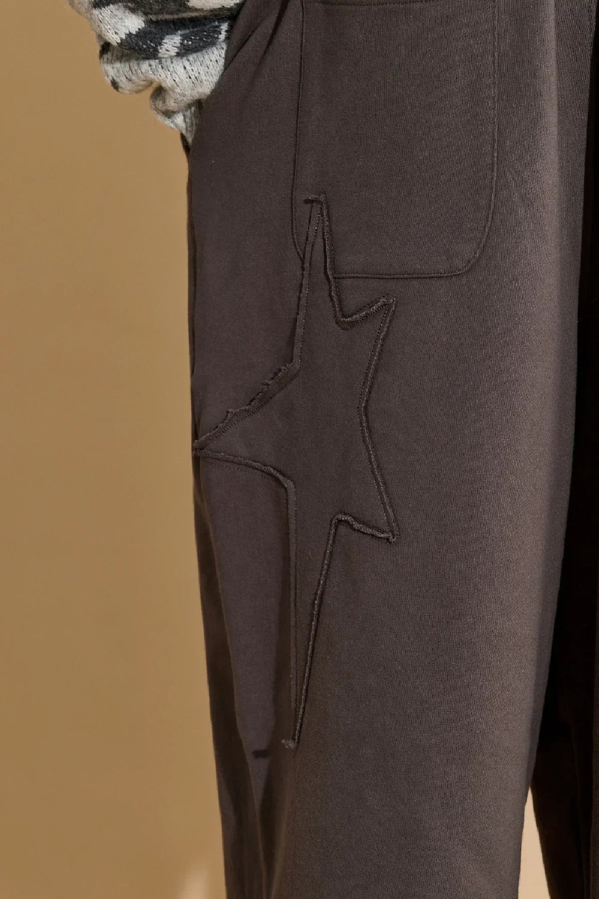 Close-up of charcoal sweatpants with star applique embroidery detail 