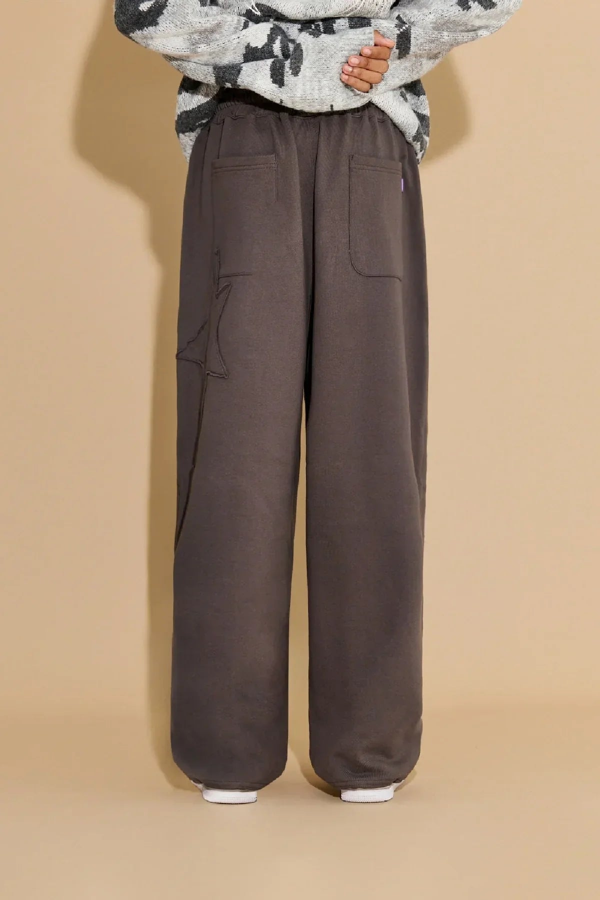 Back view of charcoal wide-leg sweatpants with star appliqué pocket and elastic waistband