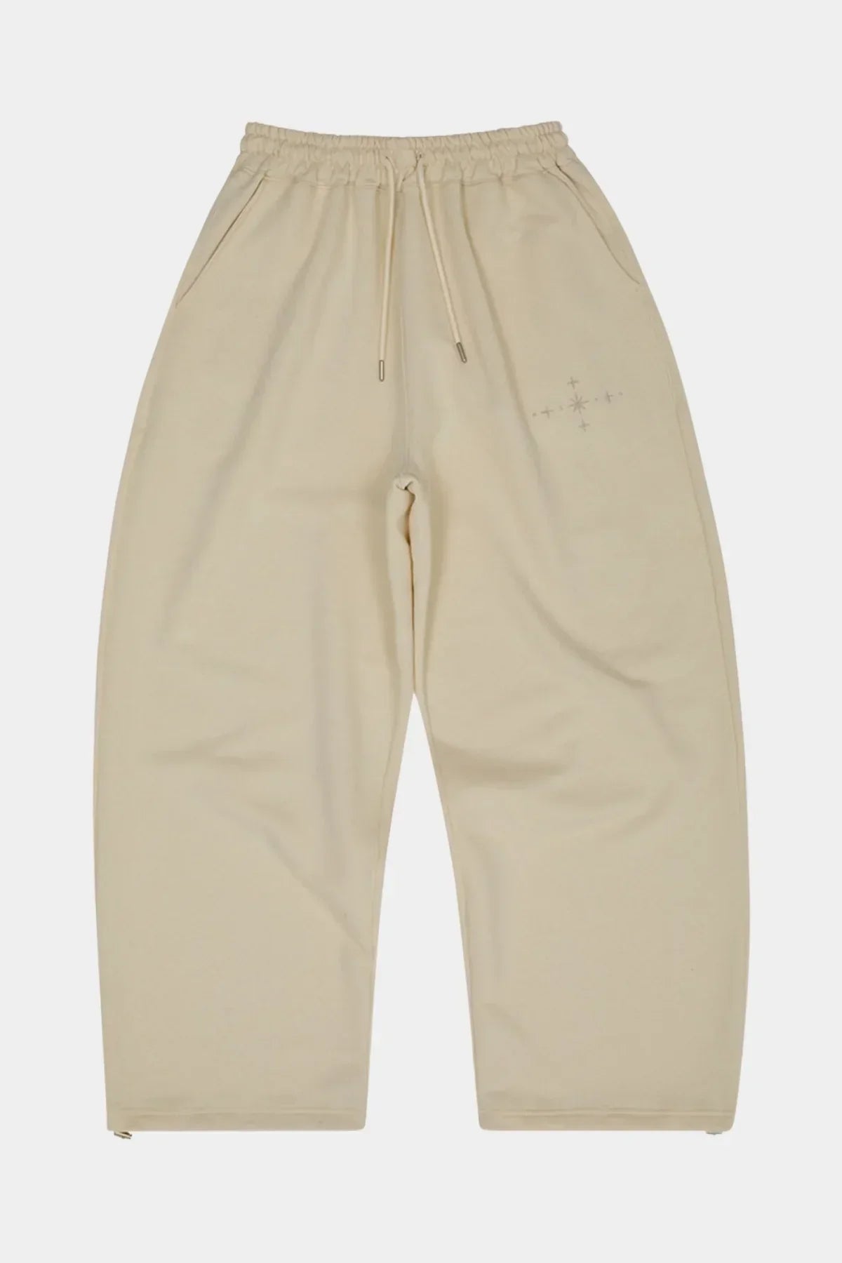 Ivory sweatpants with elastic waistband, drawstring, side pockets, and star applique embroidery
