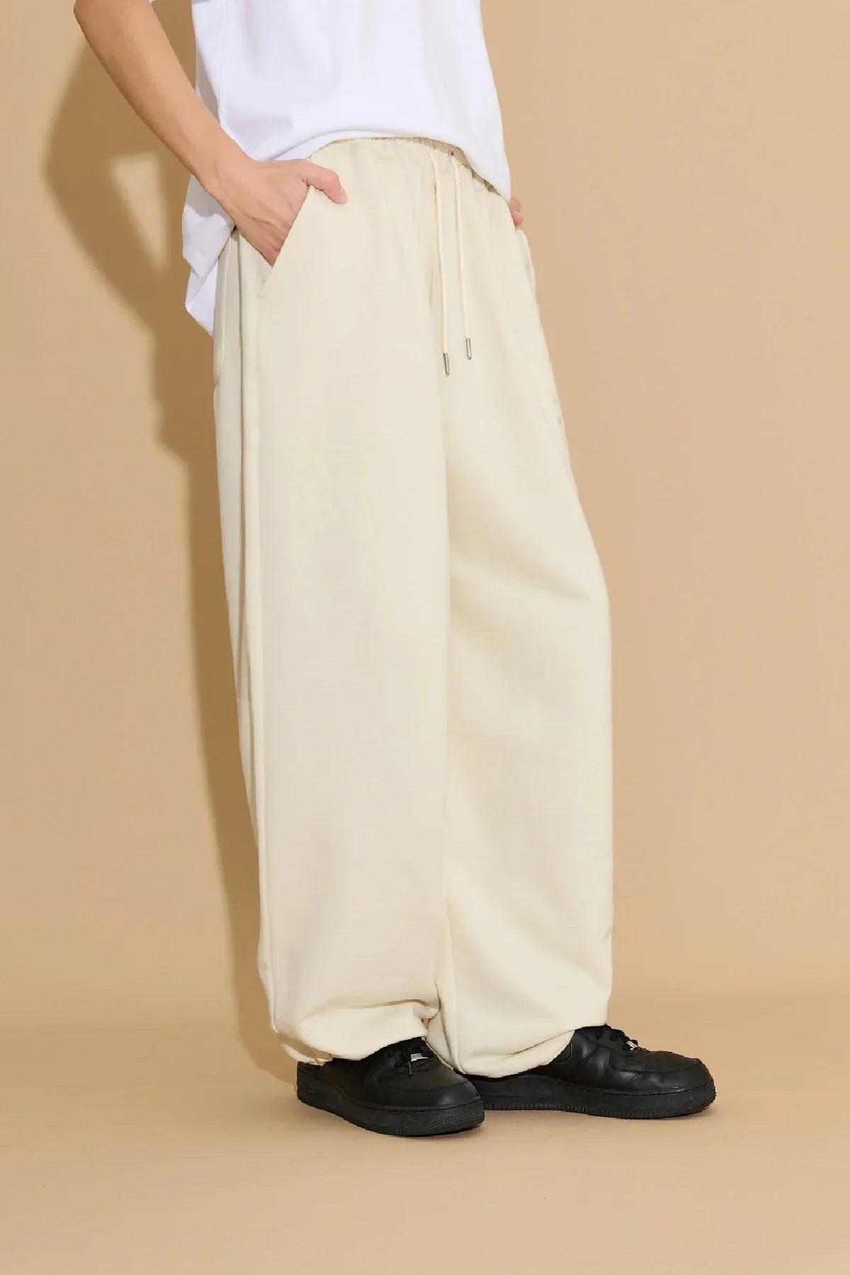 Model wearing ivory star applique embroidery sweatpants with elastic waistband and drawstring