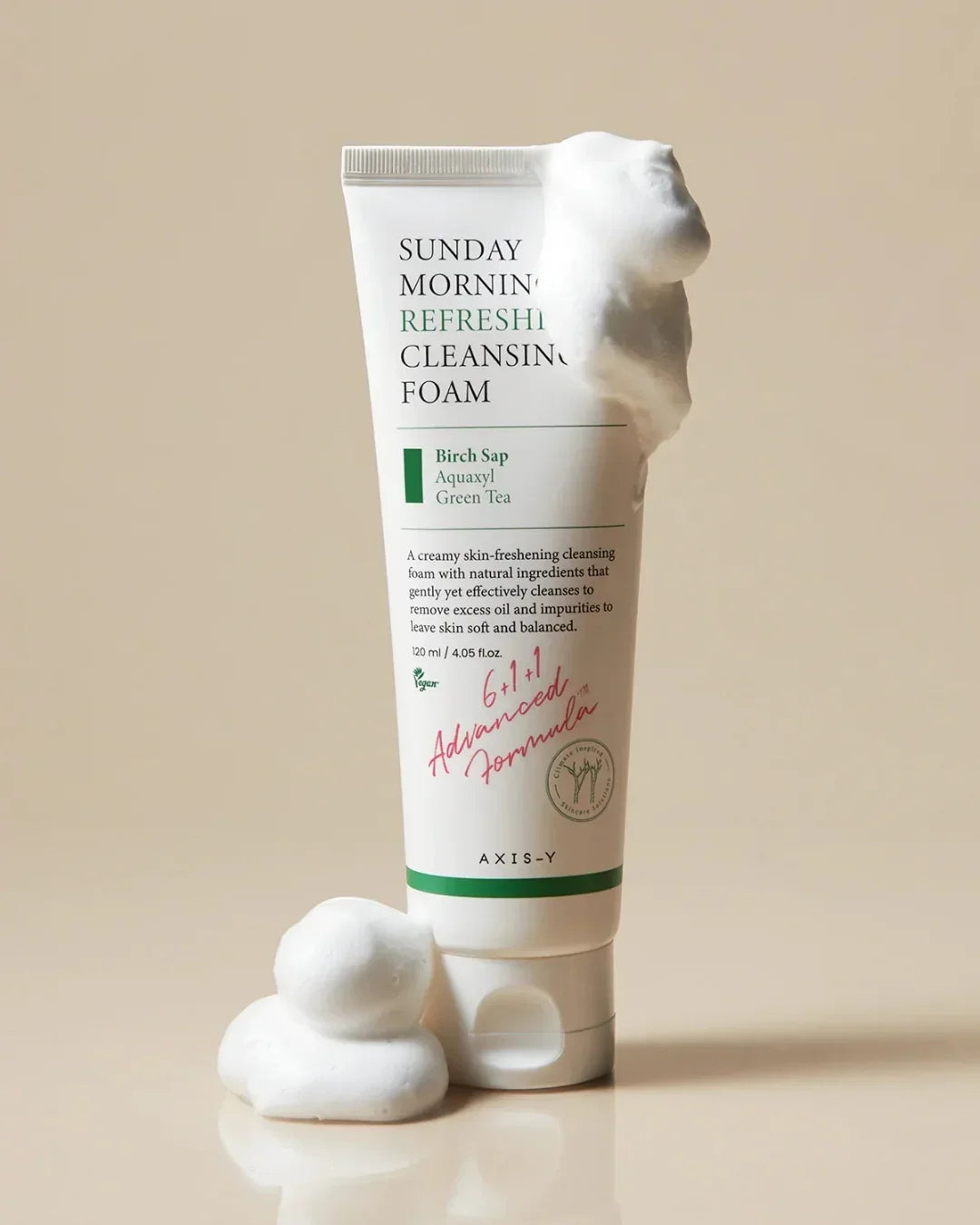 Tube of Sunday Morning Refreshing Cleansing Foam with foam on side and base on beige background
