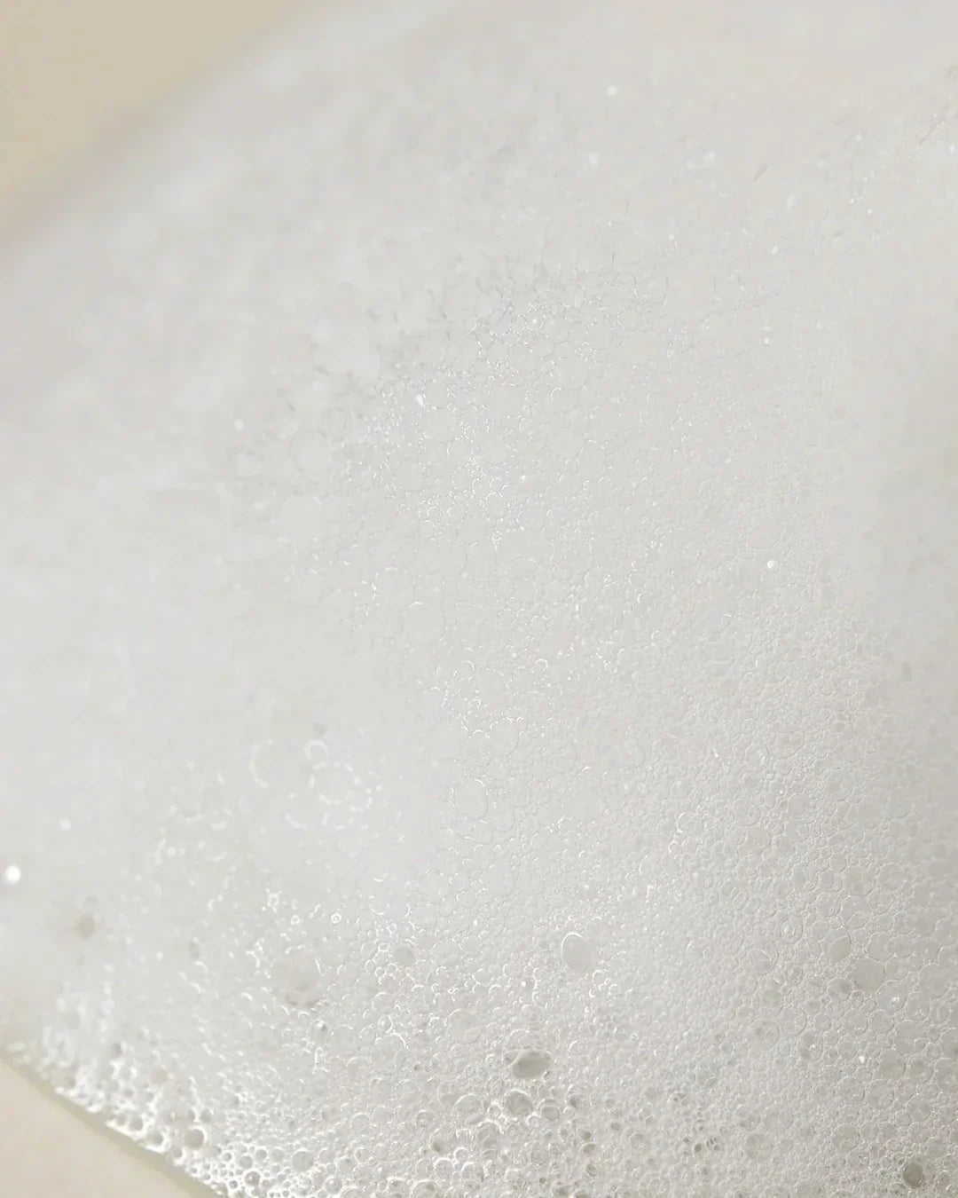 Close-up of white cleansing foam bubbles with smooth, fine texture