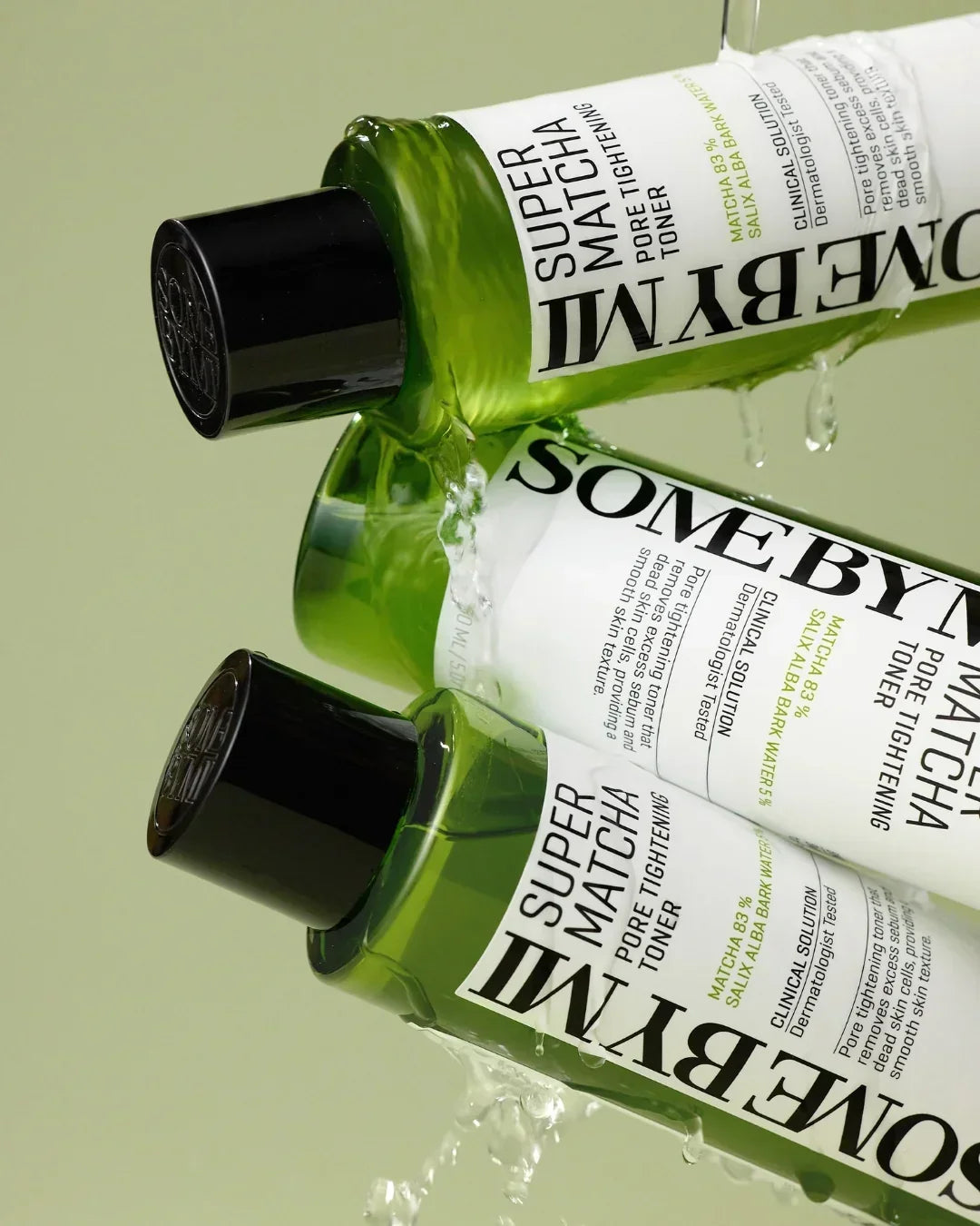 Close-up of green Some By Mi Super Matcha Pore Tightening Toner bottles with water splashes