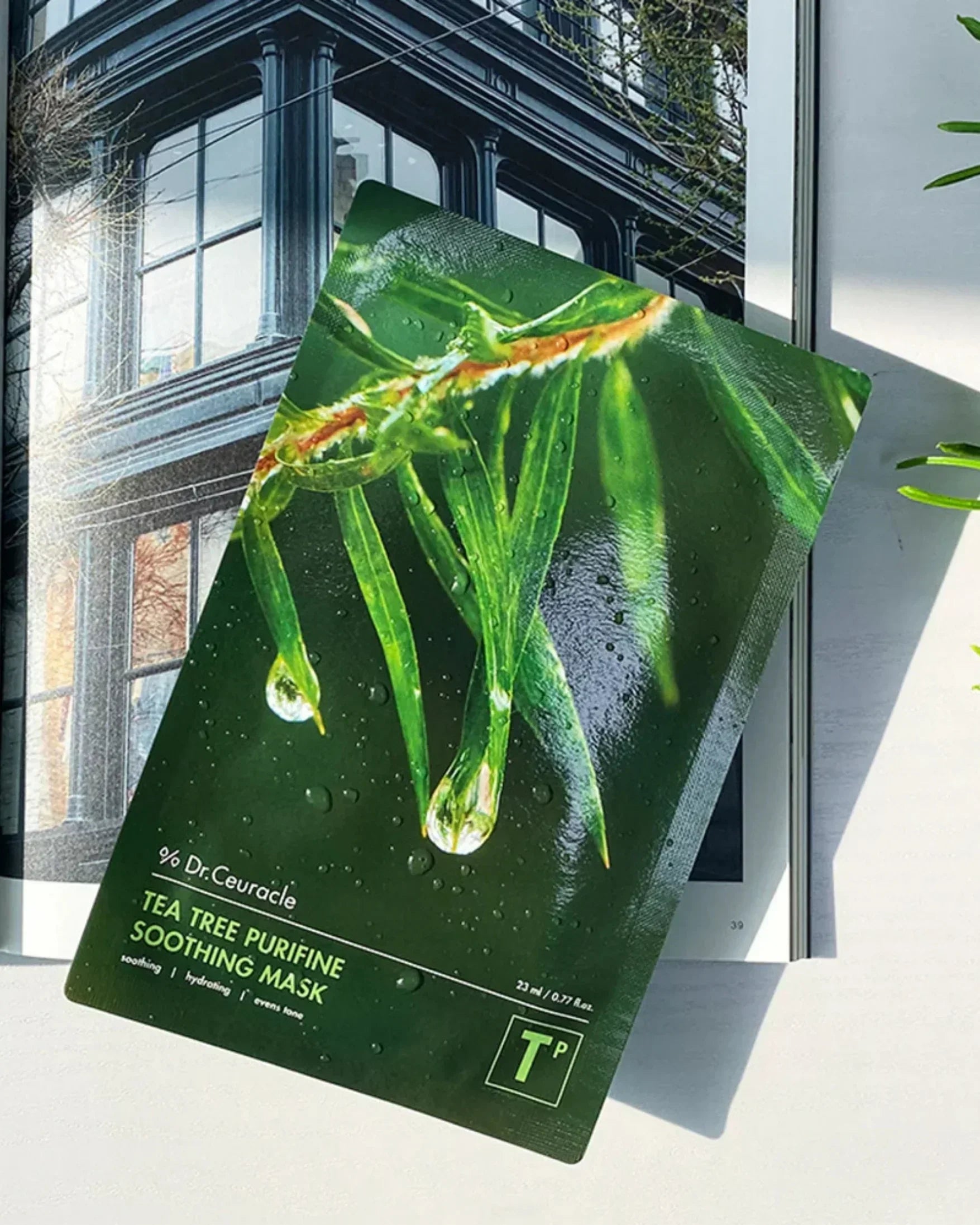 Dr.Ceuracle Tea Tree Purifine Soothing Mask package with green tea leaves and water drops on magazine background