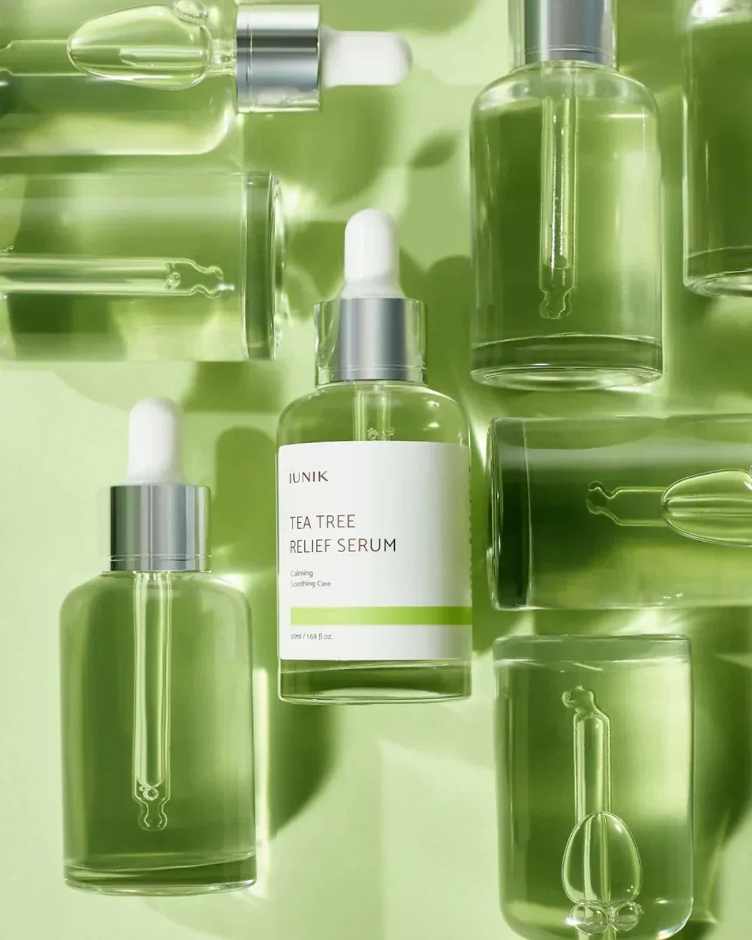 IUNIK Tea Tree Relief Serum bottle with dropper and clear green serum on light green background