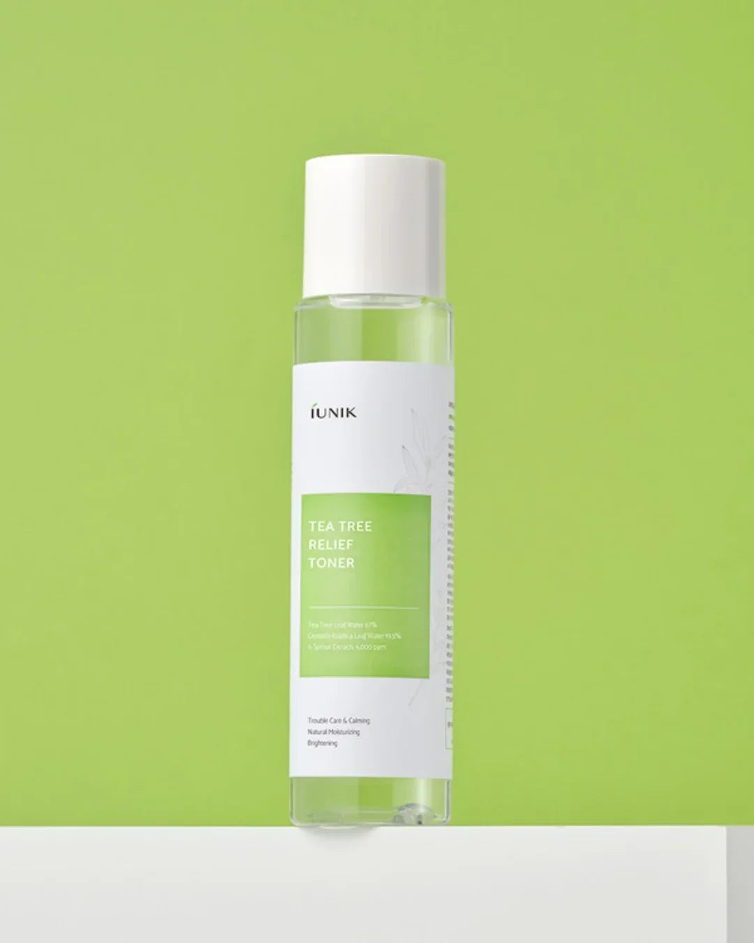 iUNIK Tea Tree Relief Toner bottle on white surface with green background, skincare product