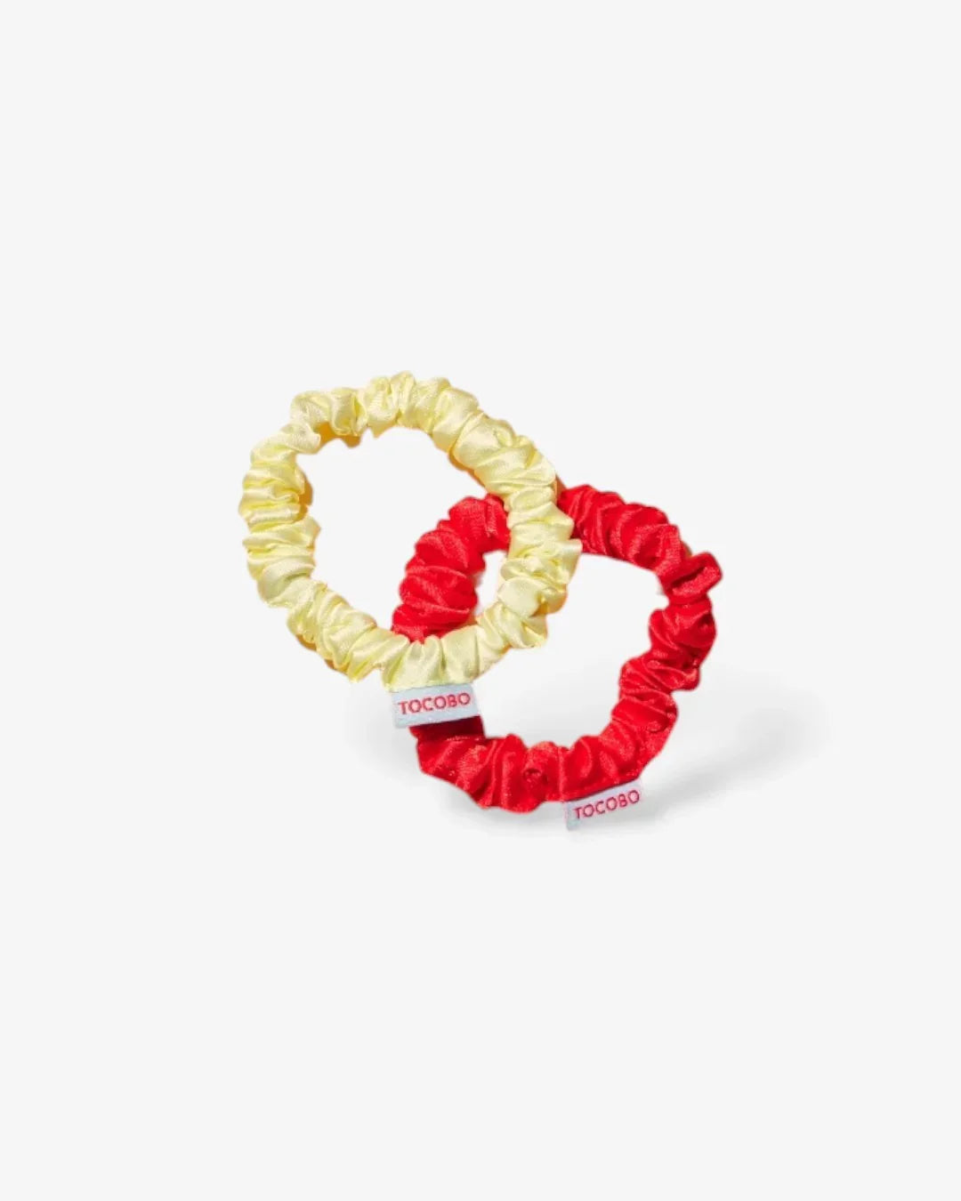 Two silk hair scrunchies in yellow and red with TOCOBO tags on white background