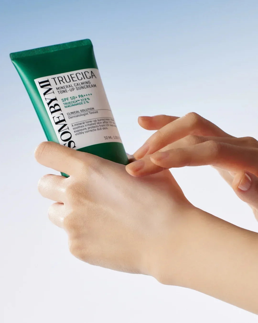 Hands applying Some By Mi Truecica Mineral Calming Tone-Up Suncream SPF 50+ PA++++ on skin