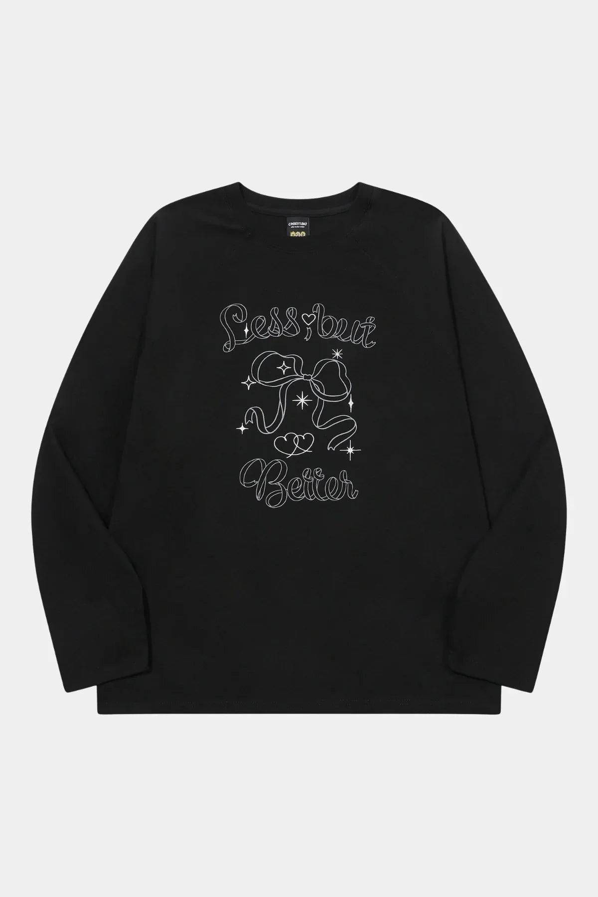 Black long sleeve raglan shirt with white graphic bow, stars, hearts, and text reading Less but Better