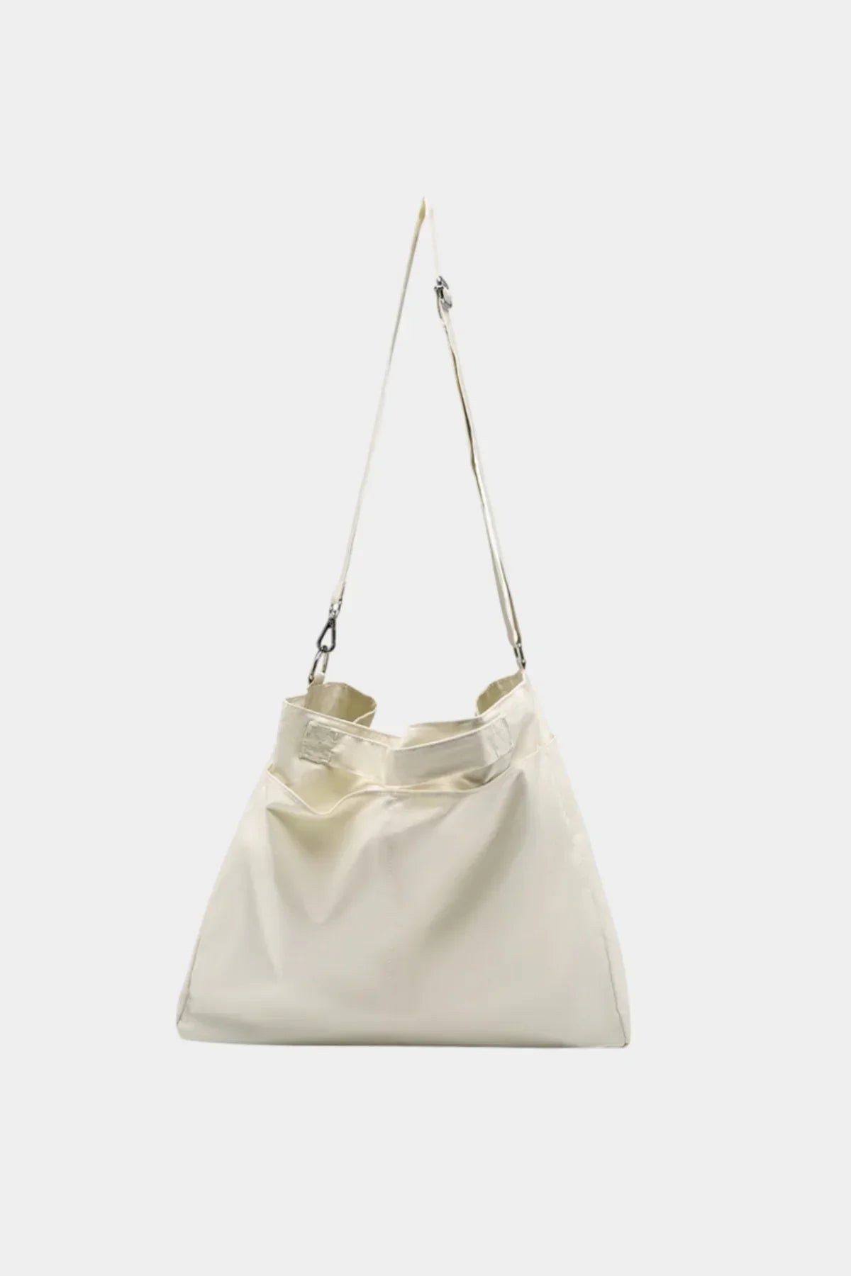 Unisex cream shoulder bag hanging with adjustable strap on white background