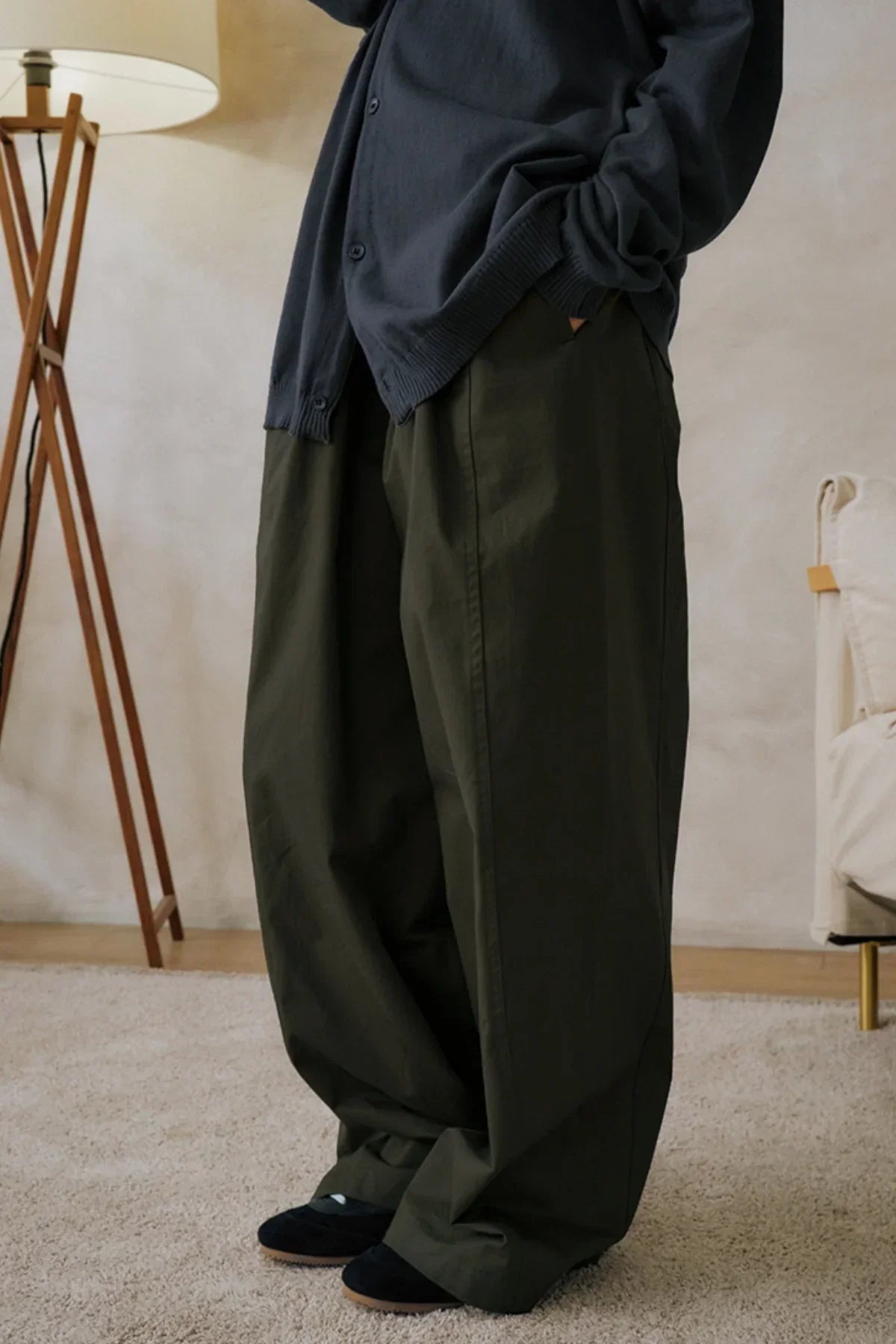 Unisex khaki wide-leg pants styled with dark blue cardigan and black shoes indoors