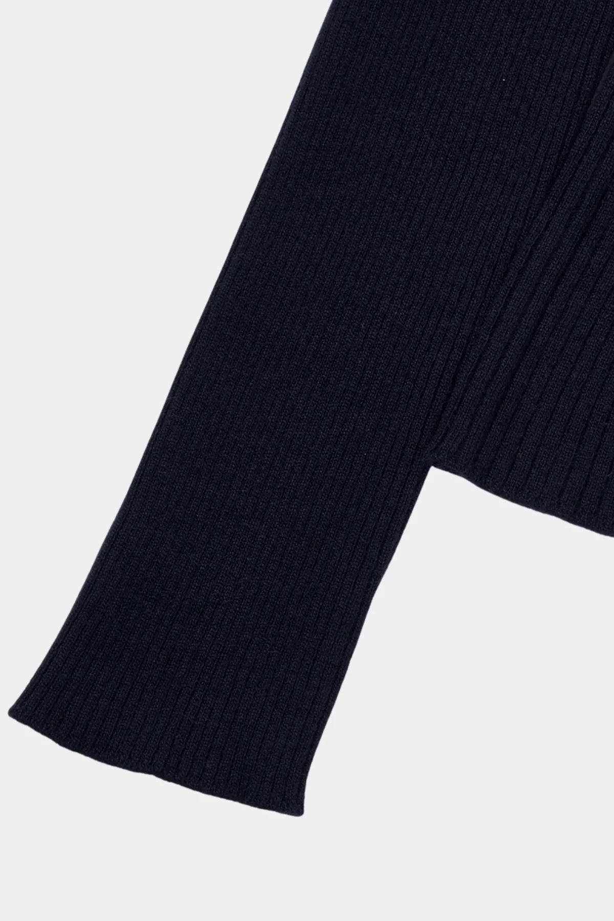 Close-up of navy blue ribbed cashmere knit sleeve with cozy textured fabric