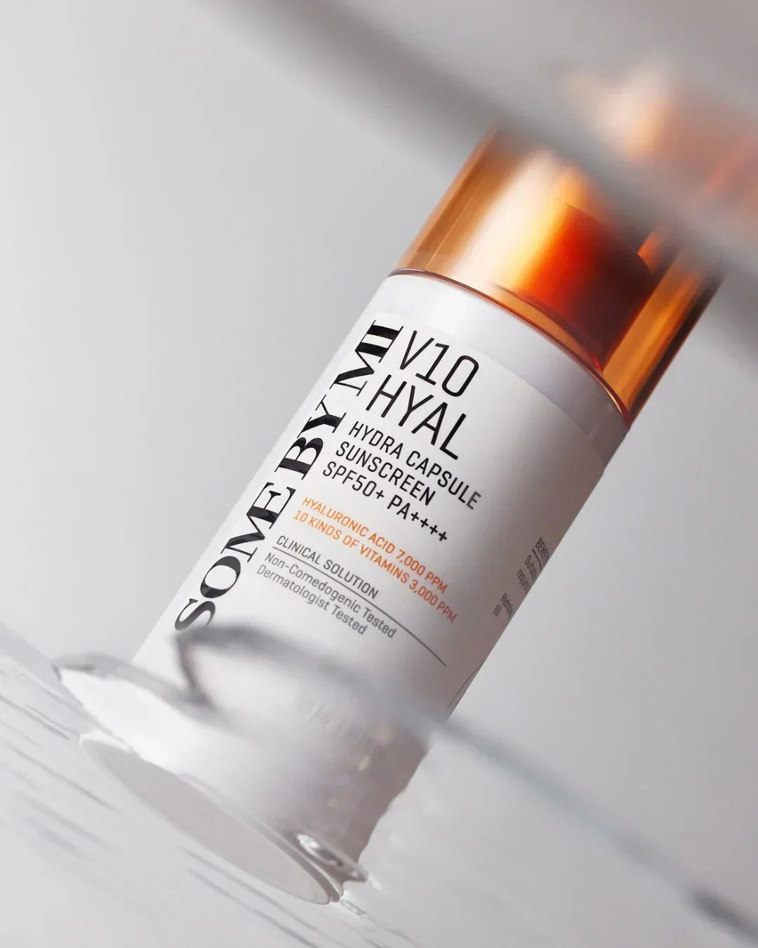 SOMEBYMI V10 Hyal hydra capsule sunscreen bottle with SPF50+ PA++++ on reflective surface