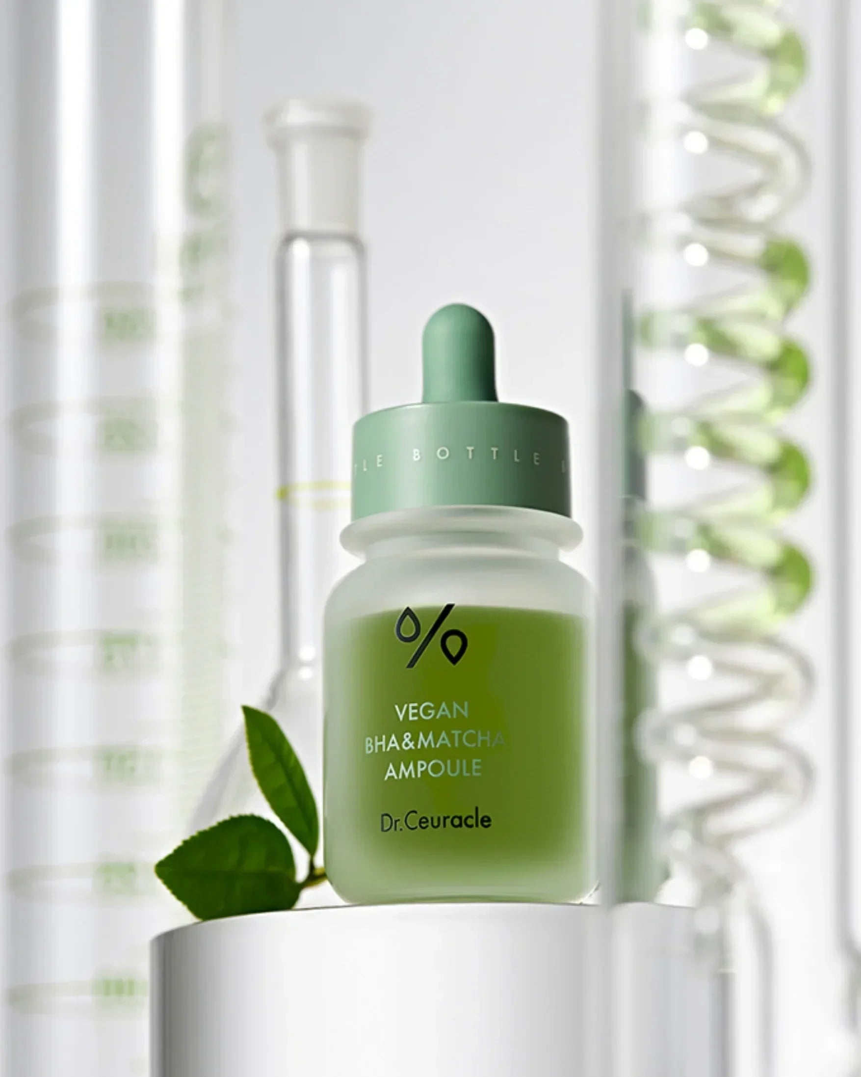 Dr. Ceuracle vegan BHA and matcha ampoule bottle with green liquid and leaves on white pedestal