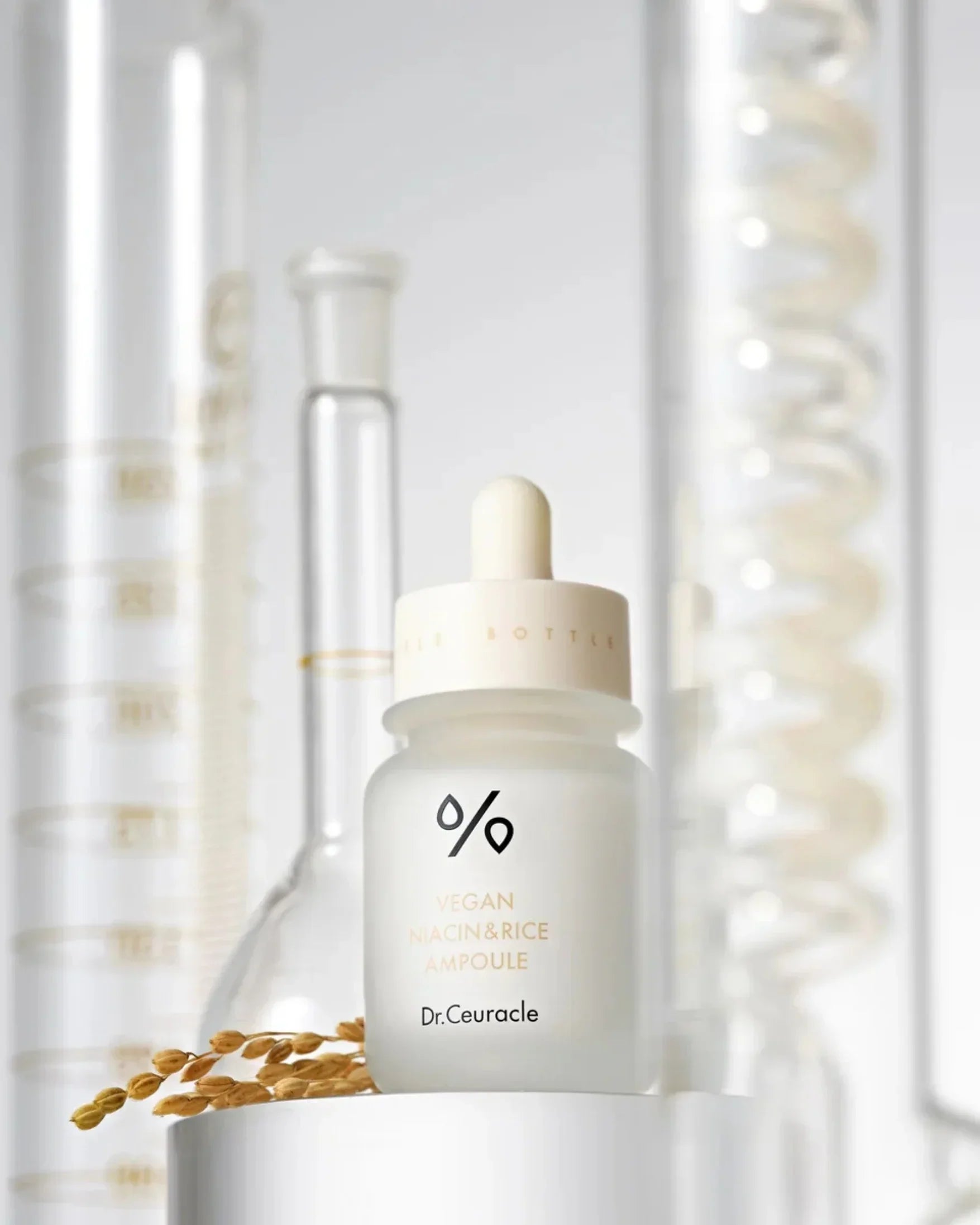 Dr. Ceuracle vegan niacin and rice ampoule bottle with scientific glassware and rice grains