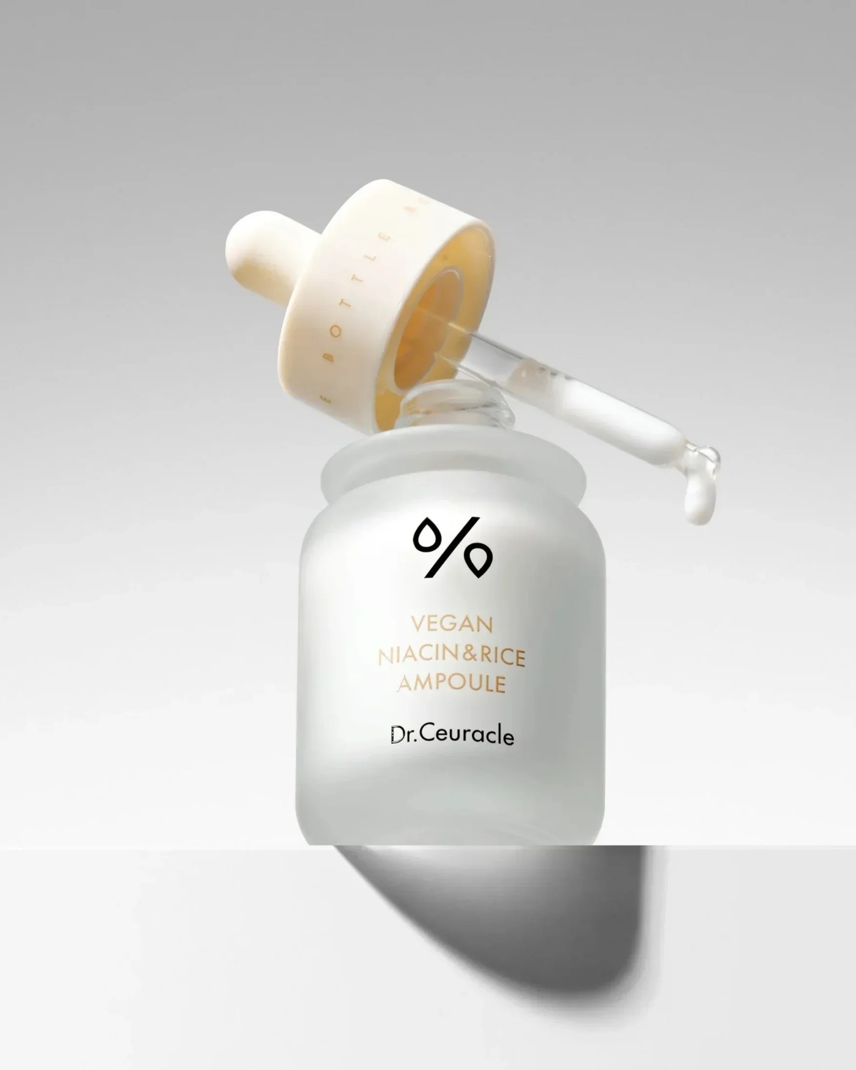 Frosted glass dropper bottle of Dr.Ceuracle Vegan Niacin & Rice Ampoule with clear serum drop