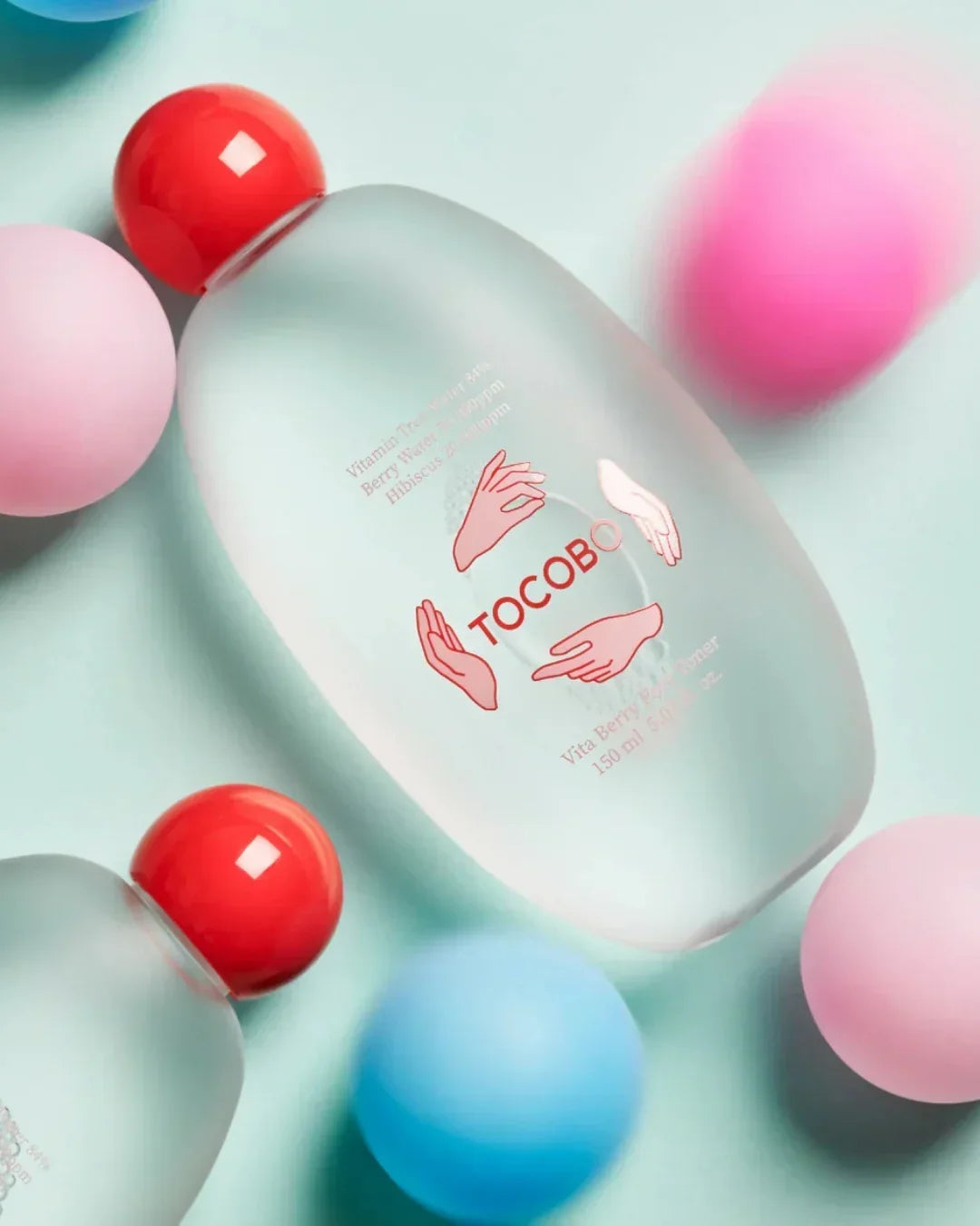 Tocobo Vita Berry Pore Toner 150ml bottle with red cap surrounded by colorful spheres on light background