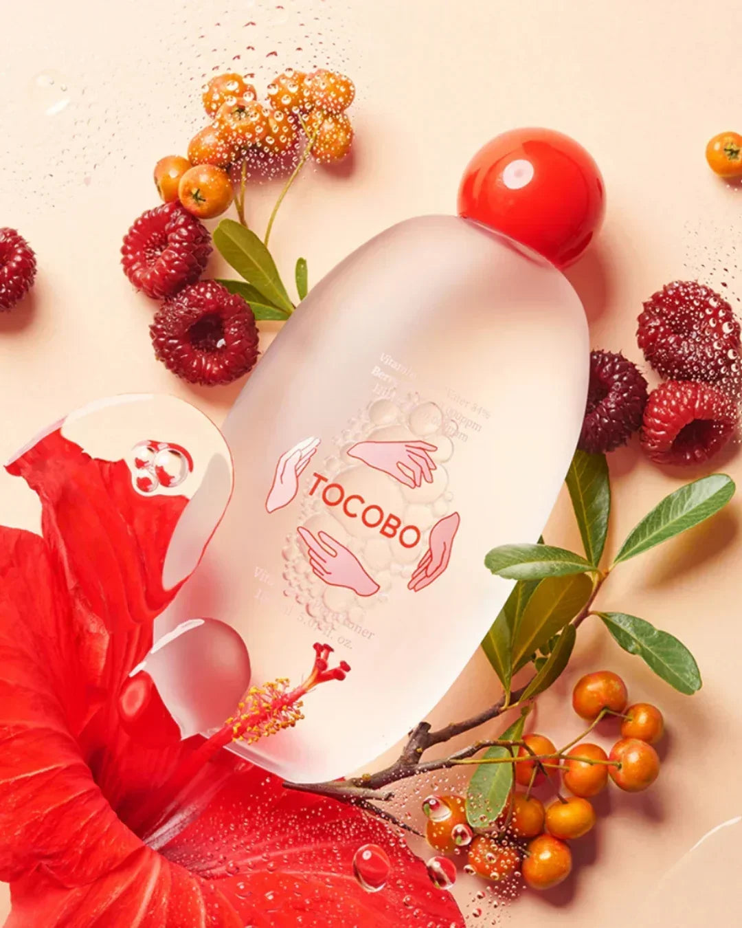Frosted bottle of Tocobo Vita Berry Pore Toner surrounded by raspberries, orange berries, and red hibiscus flower