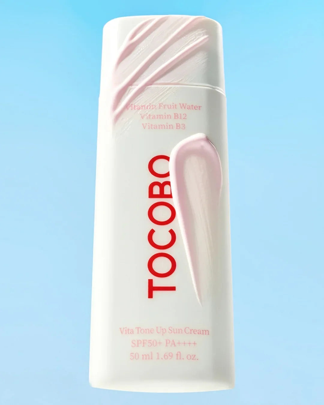 White Tocobo Vita Tone Up Sun Cream bottle with pink cream swipes on light blue background