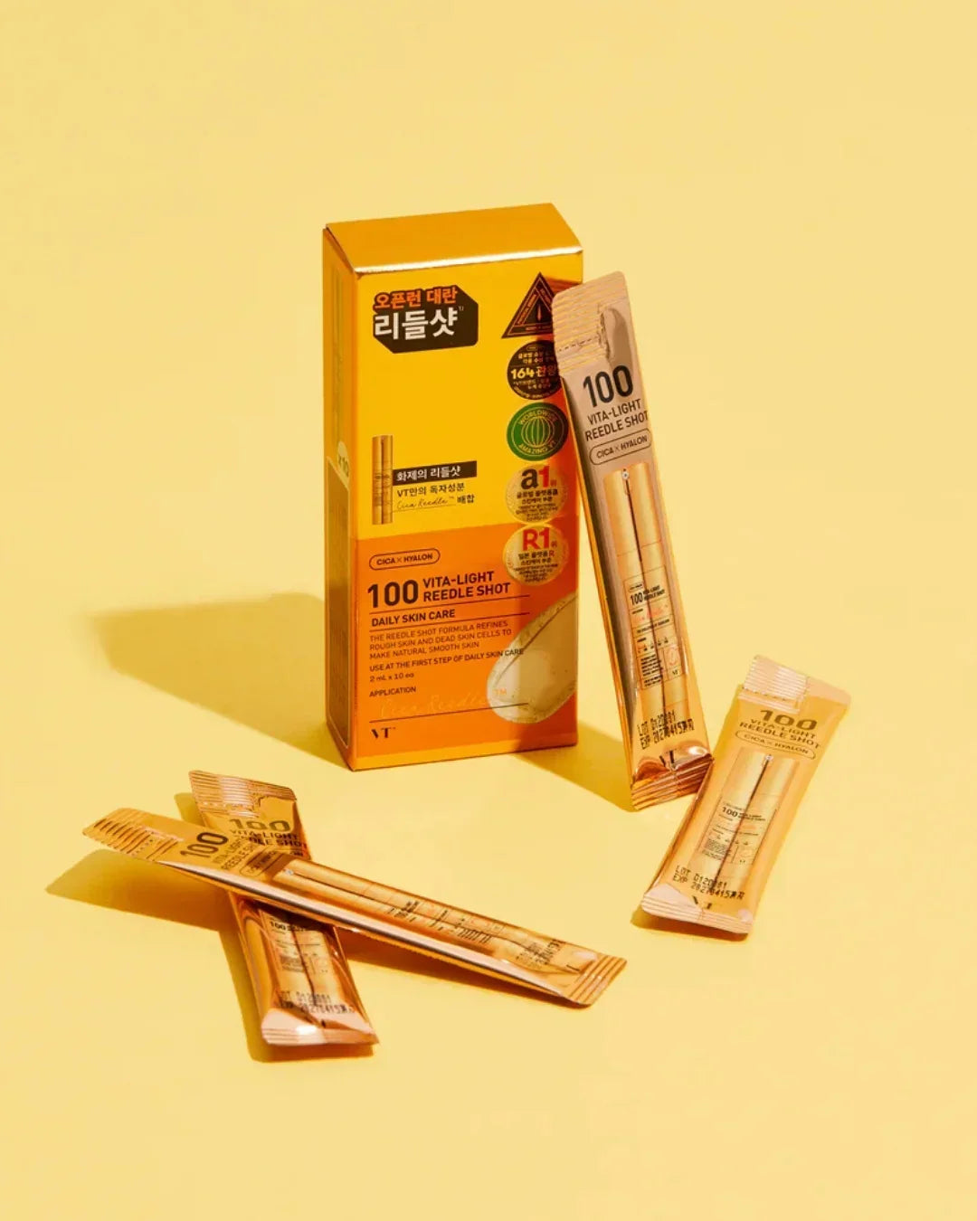 VT 100 Vita-Light Reedle Shot daily skincare sachets and orange box on yellow background