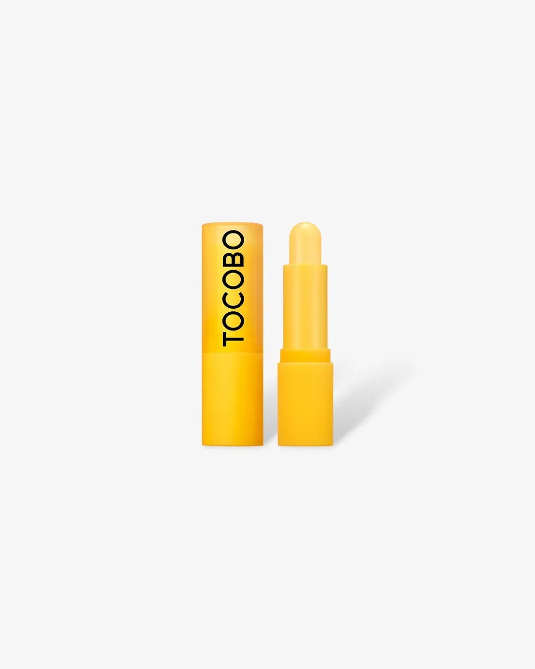 Yellow TOCOBO vitamin nourishing lip balm with cap removed on white background