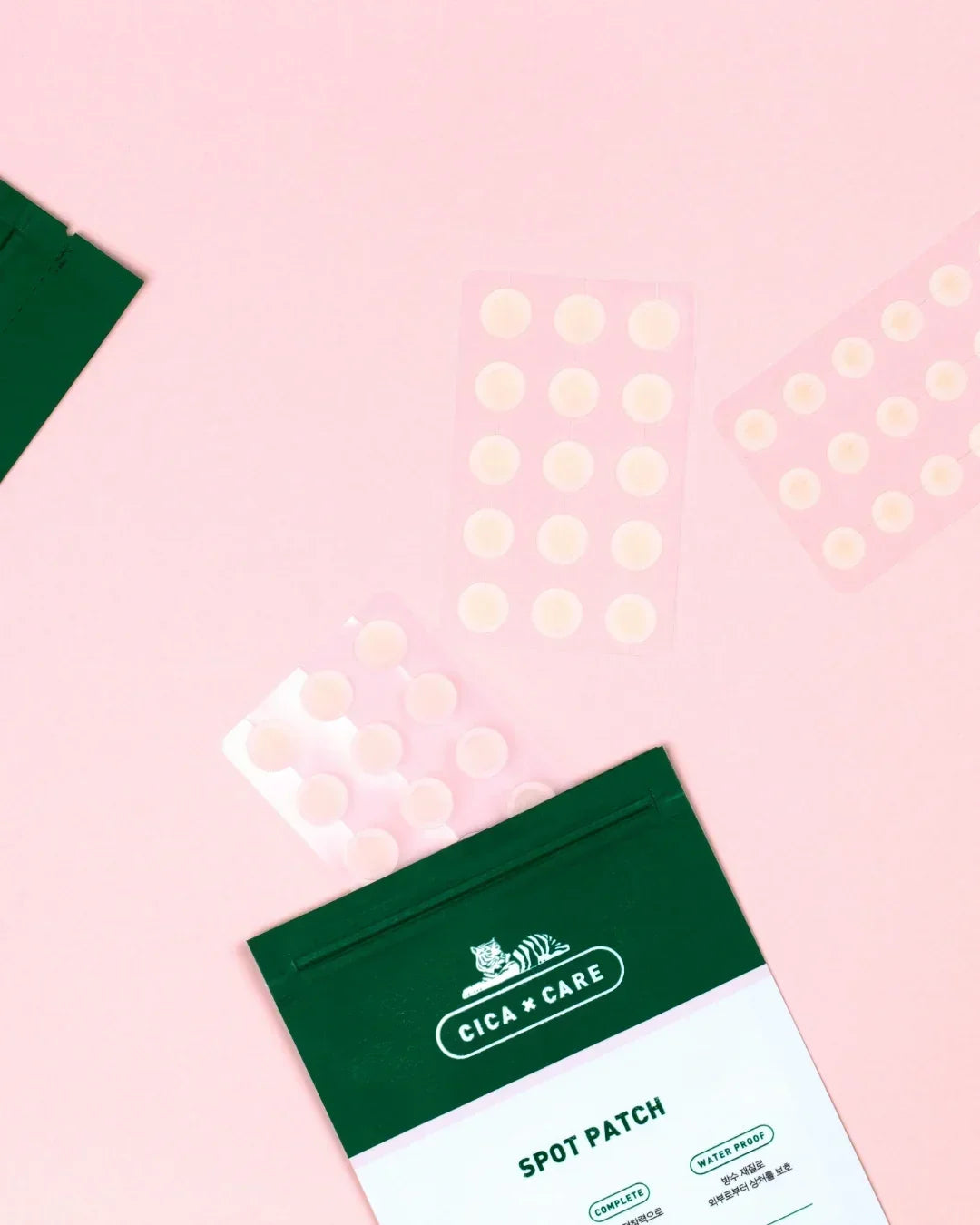 Cica Care spot patch acne treatment with three blister packs on a pink background