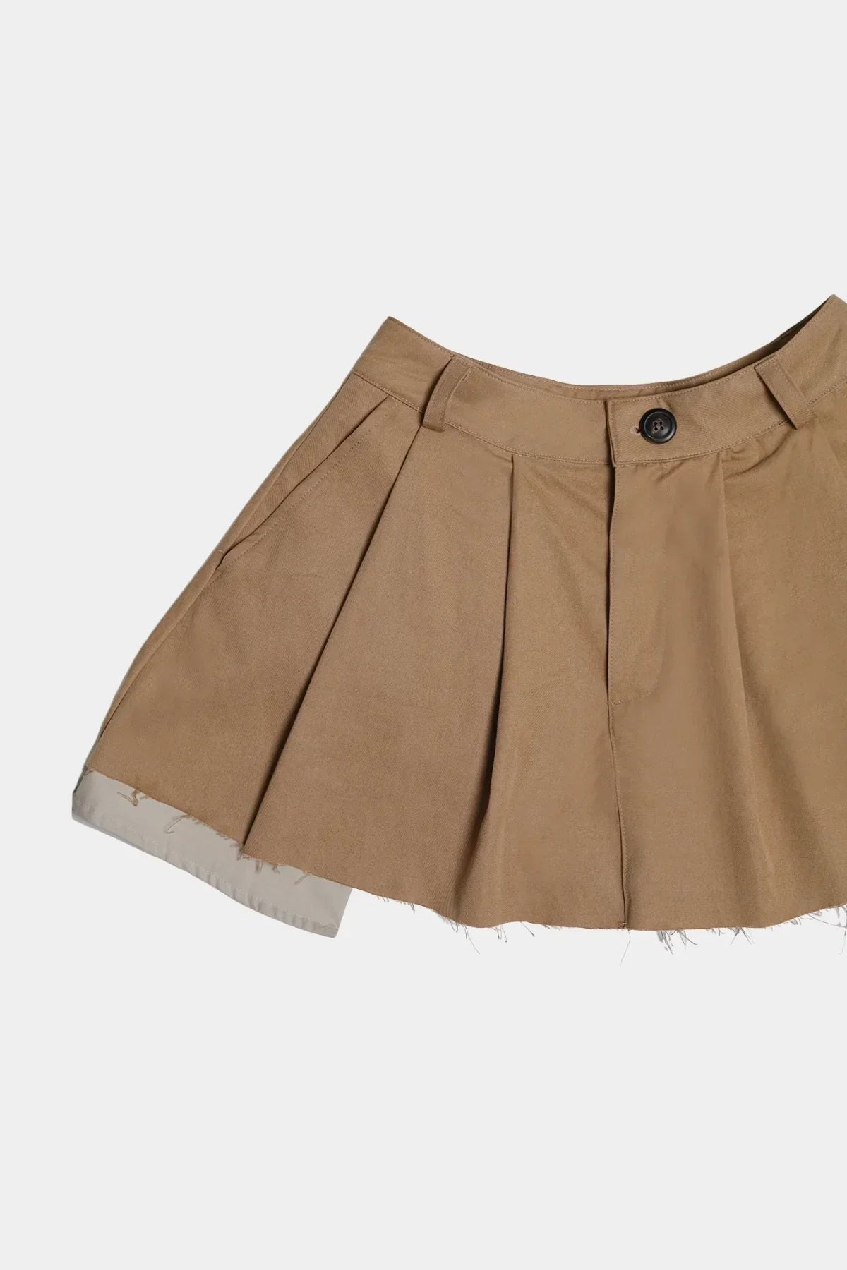 Close-up of beige wide tuck mini skirt with pleats and exposed hem detail