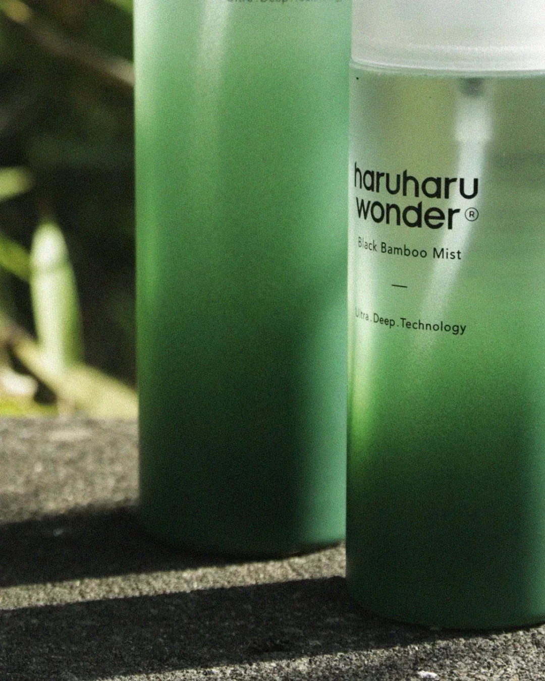Haru Haru Wonder Black Bamboo Mist skincare bottle with green gradient design on outdoor stone surface
