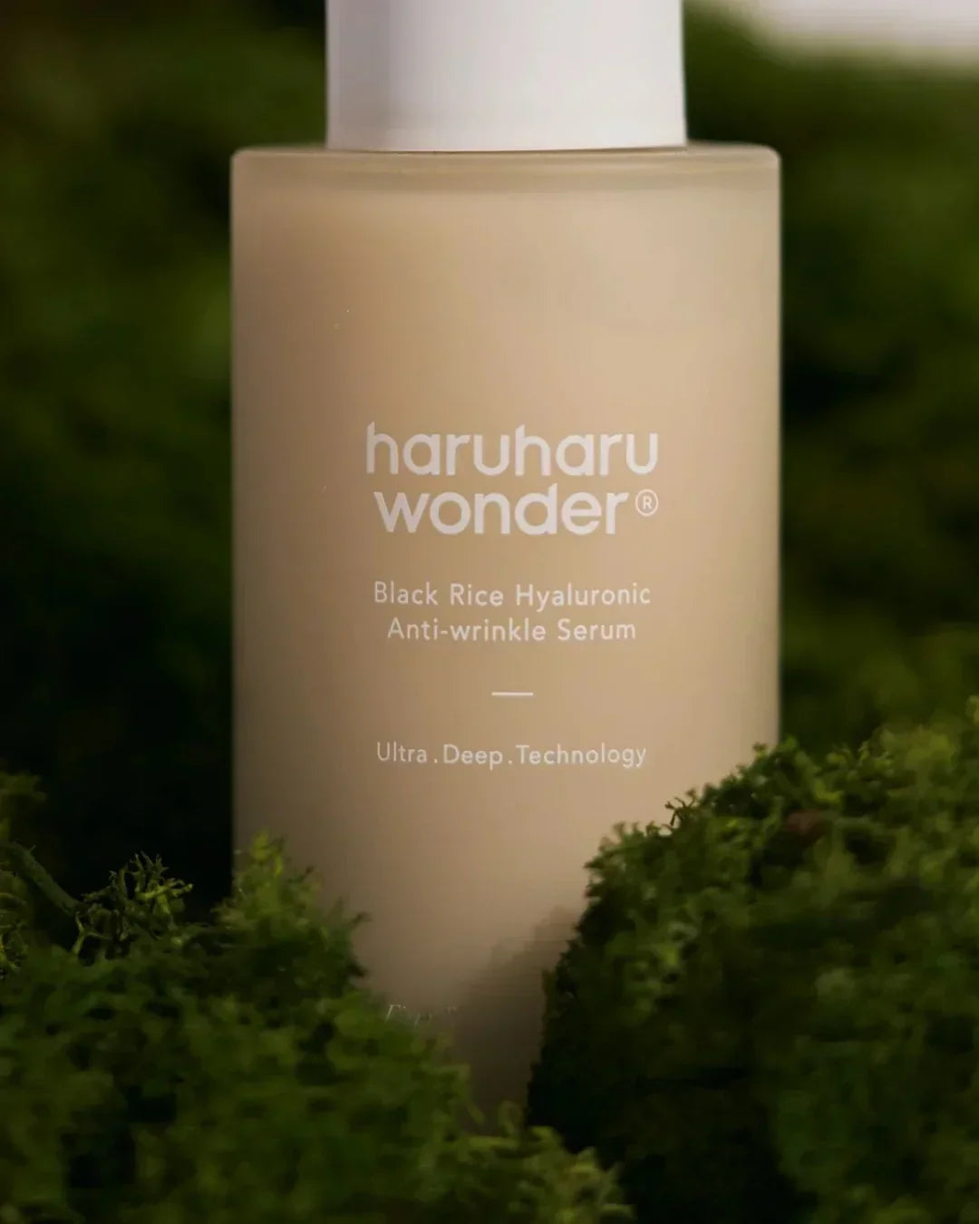 Haruharu Wonder Black Rice Hyaluronic Anti-wrinkle Serum bottle surrounded by green moss