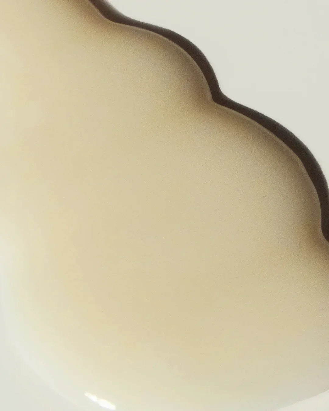 Close-up of smooth beige hyaluronic anti-wrinkle serum texture with subtle curves