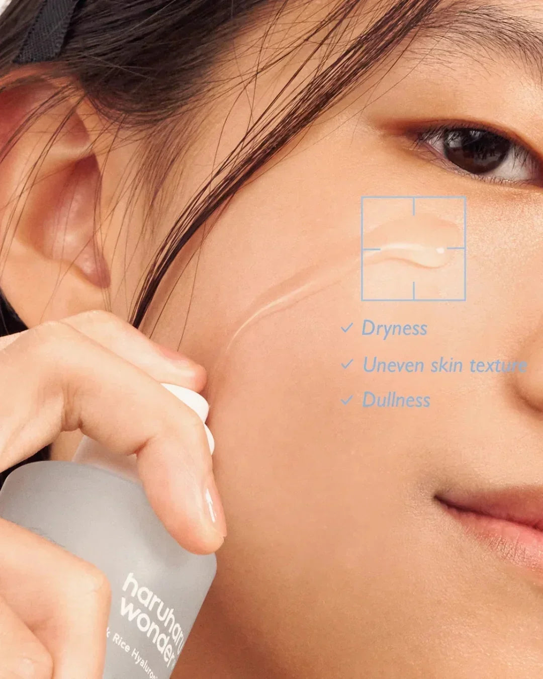 Close-up of woman applying Haruharu Wonder black rice hyaluronic essence to cheek, highlighting dryness and dullness
