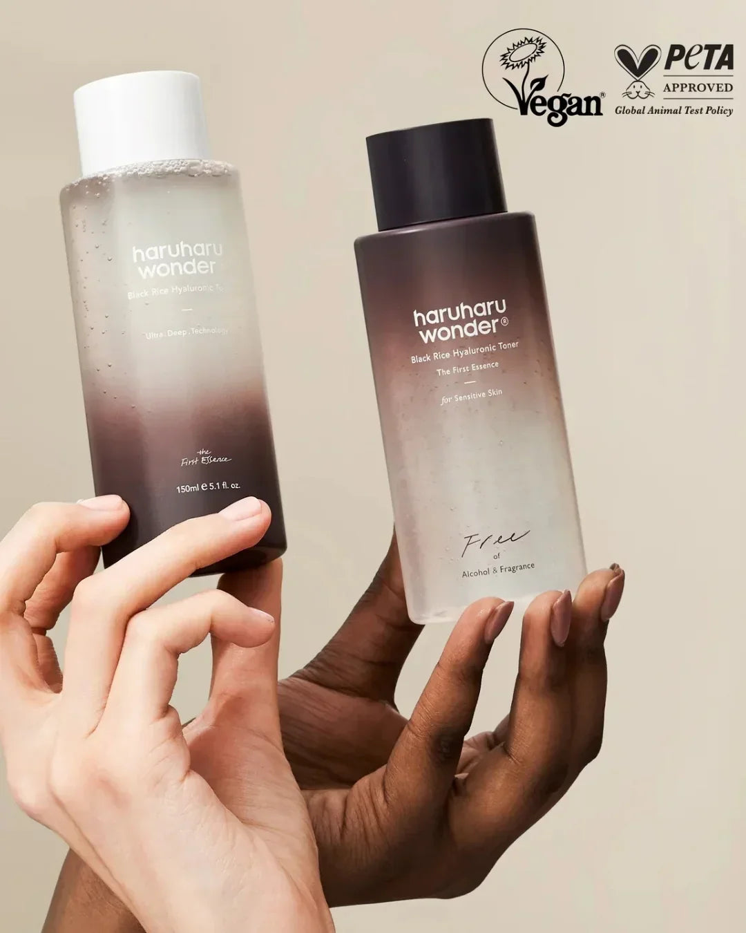 Two hands holding Haruharu Wonder Black Rice Hyaluronic Toner bottles with vegan and PETA approval logos