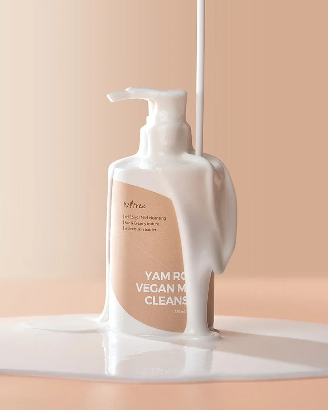 Isntree Yam Root Vegan Milk Cleanser bottle with creamy white liquid poured over it on beige background