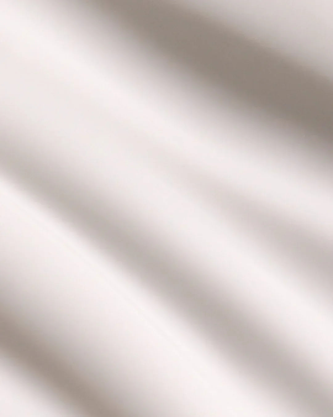 Close-up of creamy white yam root vegan milk cleanser texture on light surface