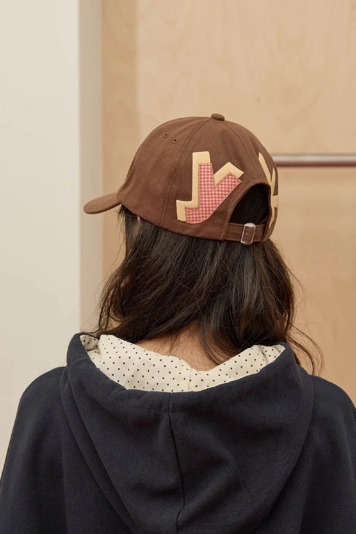 Brown baseball cap with check applique, worn by woman in hoodie, Korean fashion style