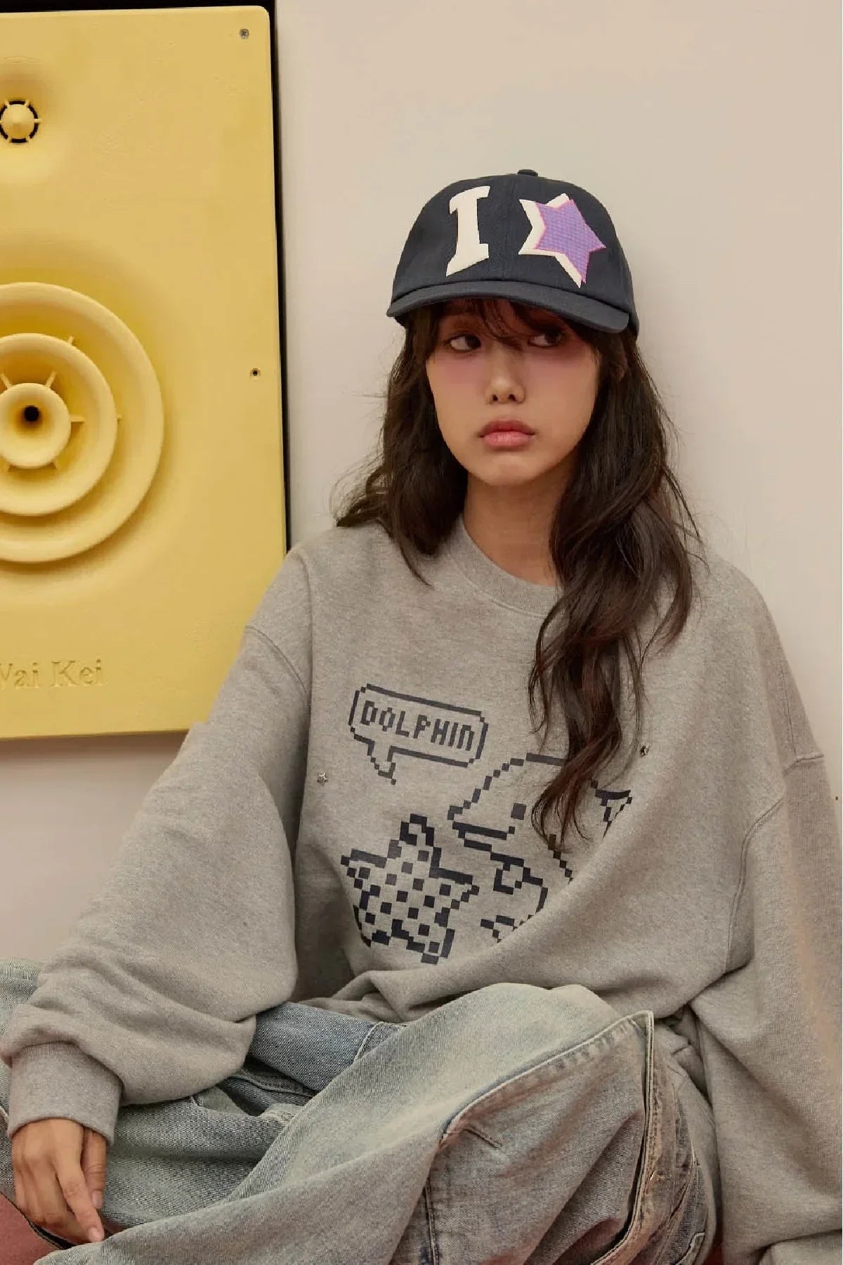 Woman wears navy YK check applique ball cap and gray dolphin graphic sweatshirt, Korean fashion
