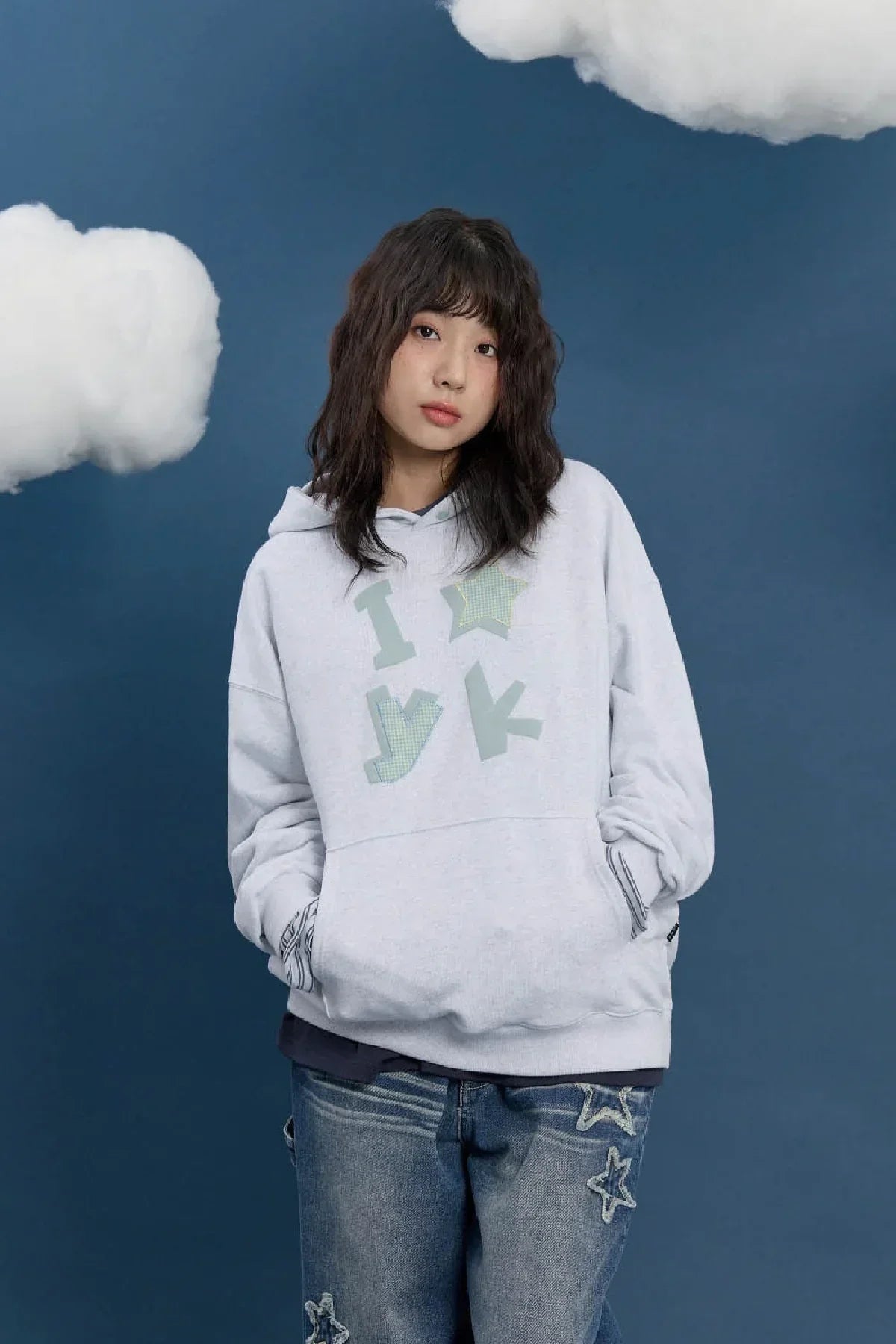Woman in a melange white YK applique hoodie, Korean fashion, blue background, clouds, Malkn