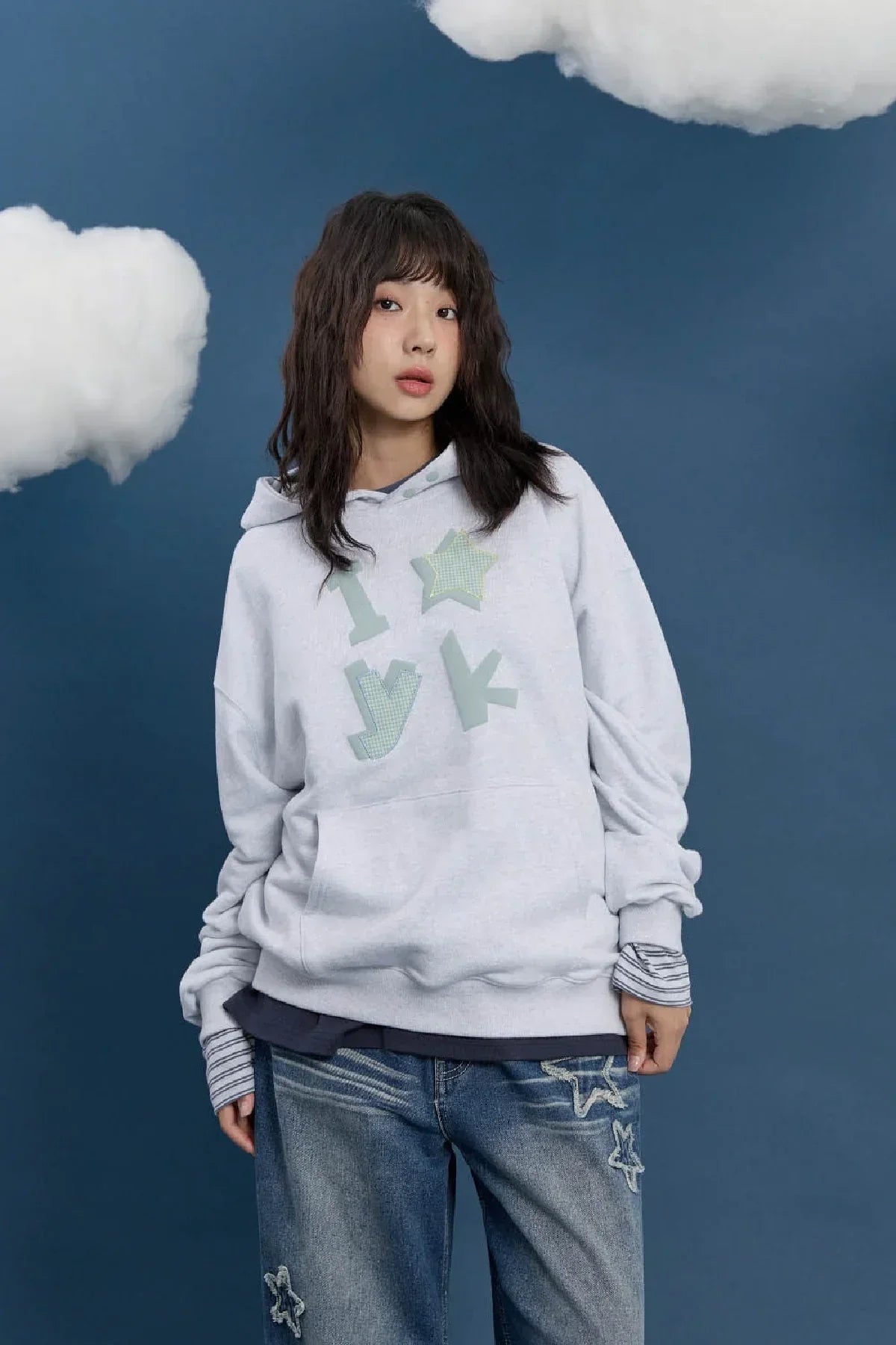 Young woman in a light grey YK check applique hoodie and star patch jeans, Korean fashion