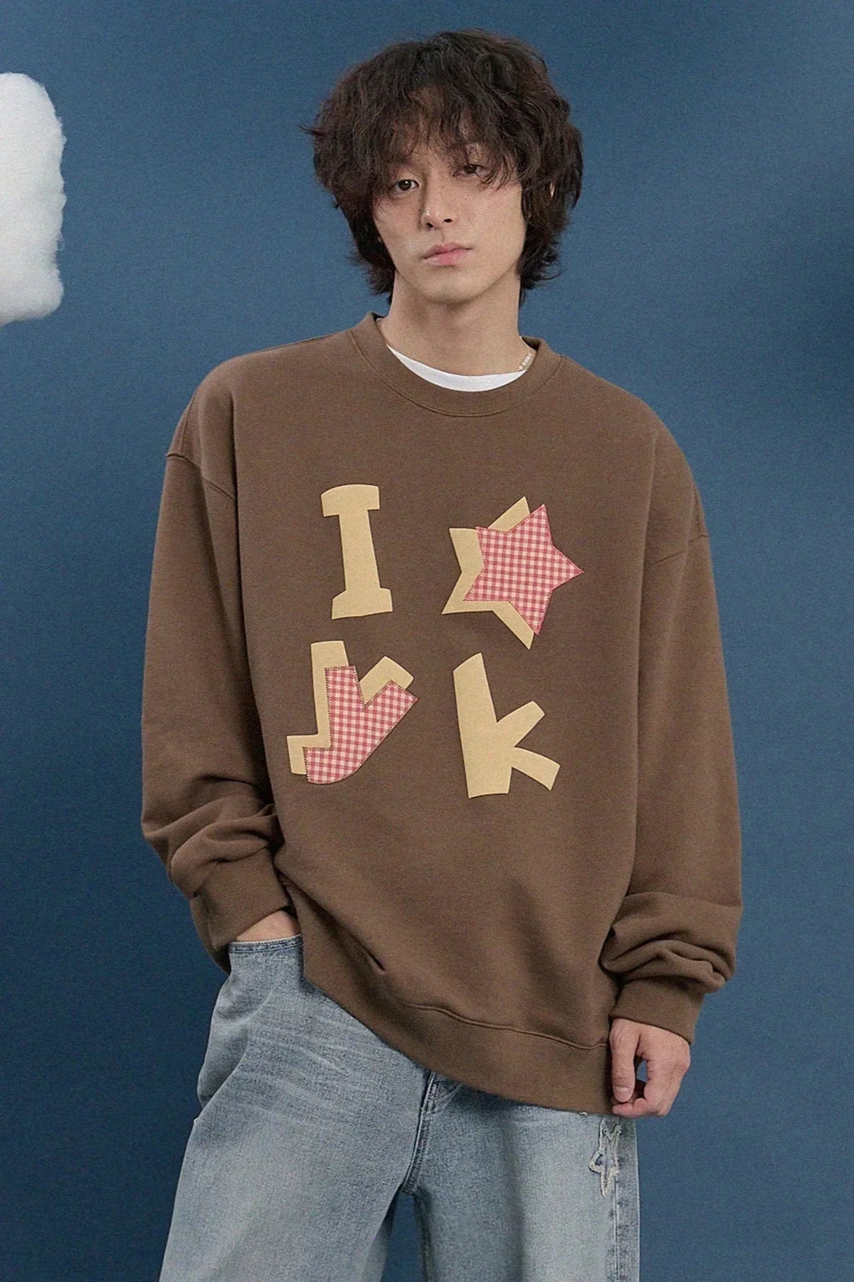 Model in brown Korean fashion sweatshirt with applique design, blue background, Malkn UK