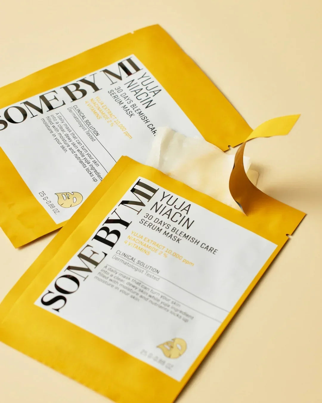Some By Mi Yuja Niacin 30 Days Blemish Care Serum Mask in yellow packaging, one opened with white sheet mask visible