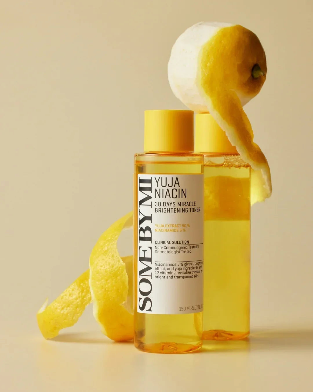 SOME BY MI Yuja Niacin 30 Days Miracle Brightening Toner bottles with lemon peel on beige background
