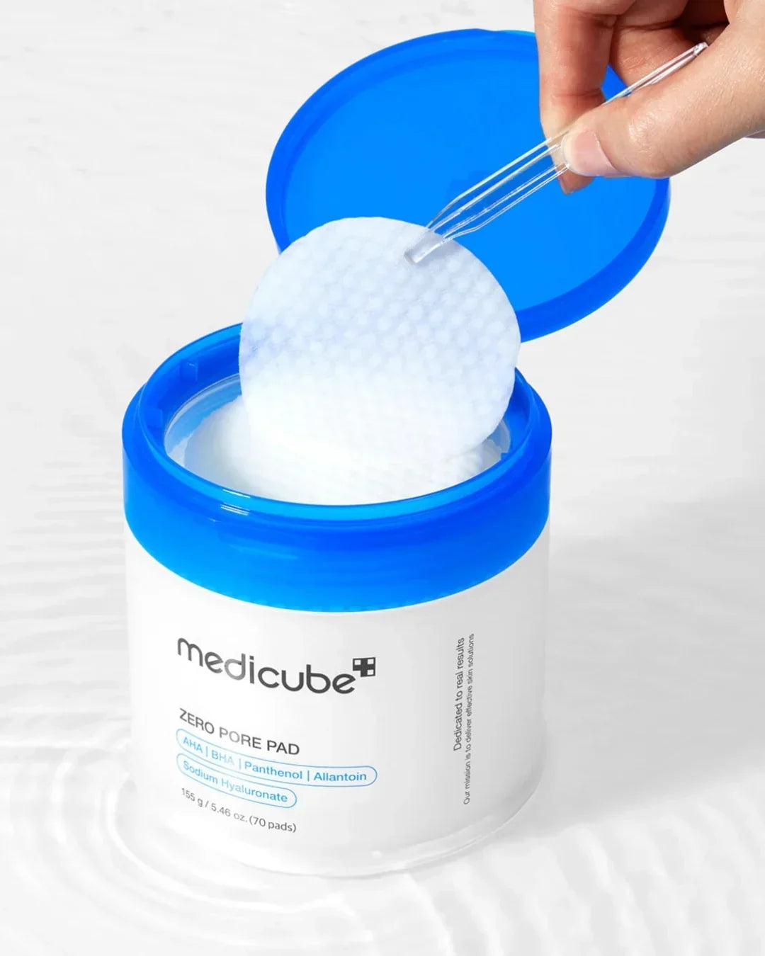 Medicube Zero Pore Pad container with blue lid and textured cotton pad held by tweezers